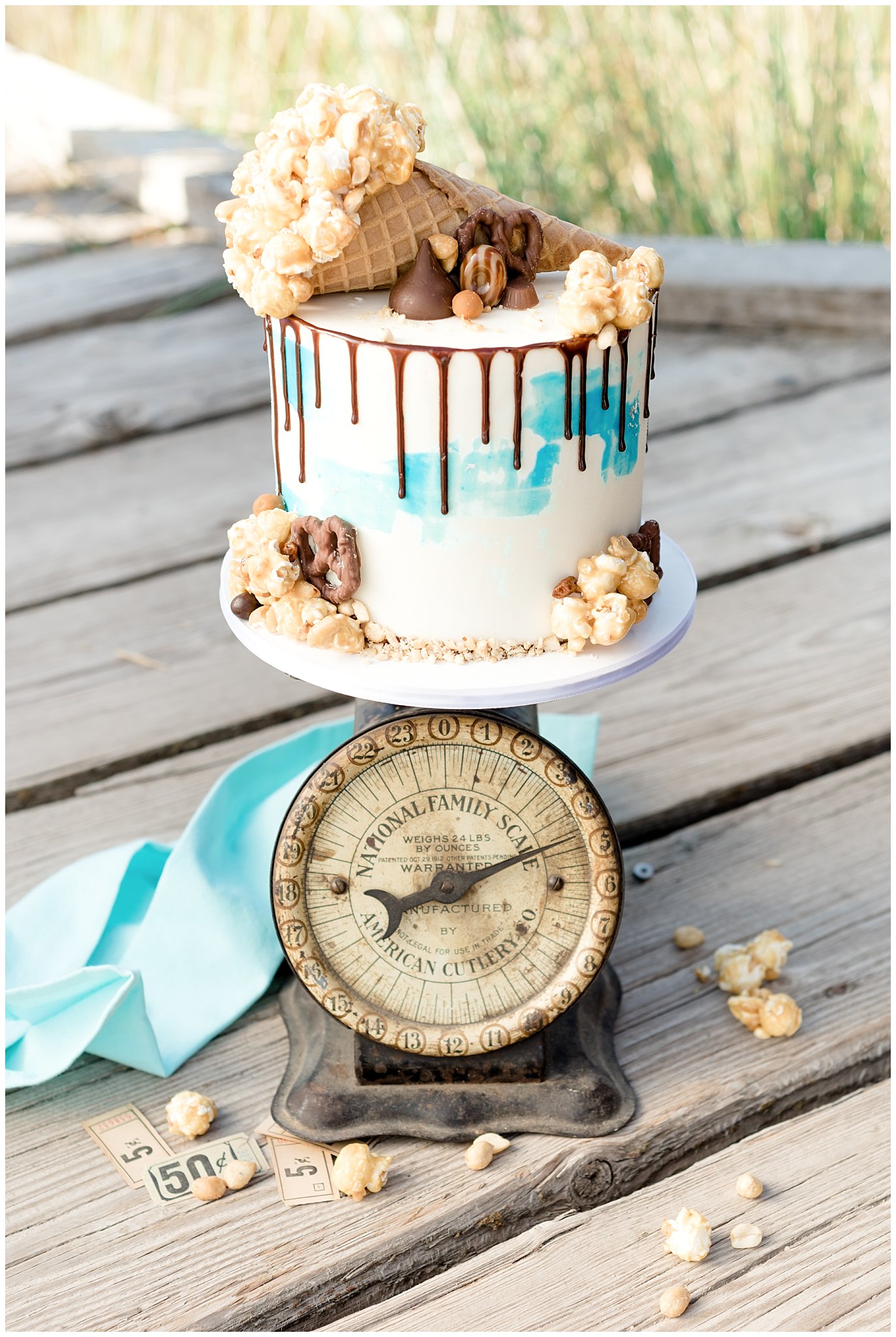 Caramel popcorn, hershey kisses and toffee wedding cake on a vintage scale at the boardwalk in Utah | Jessie and Dallin Photography | Utah Wedding Photographers