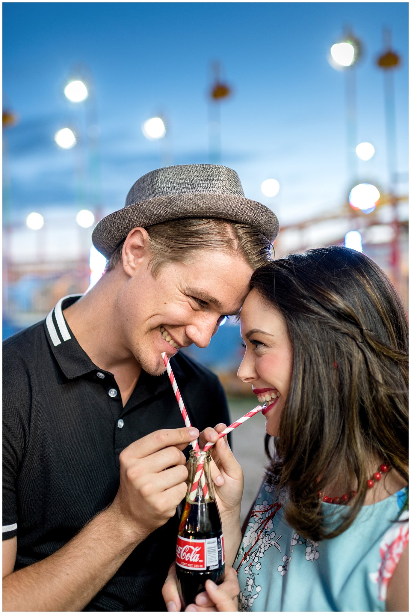 Couple drinks Coca-Cola from straws at the state fair during their carnival engagement session | Jessie and Dallin Photography | Utah Wedding Photographers