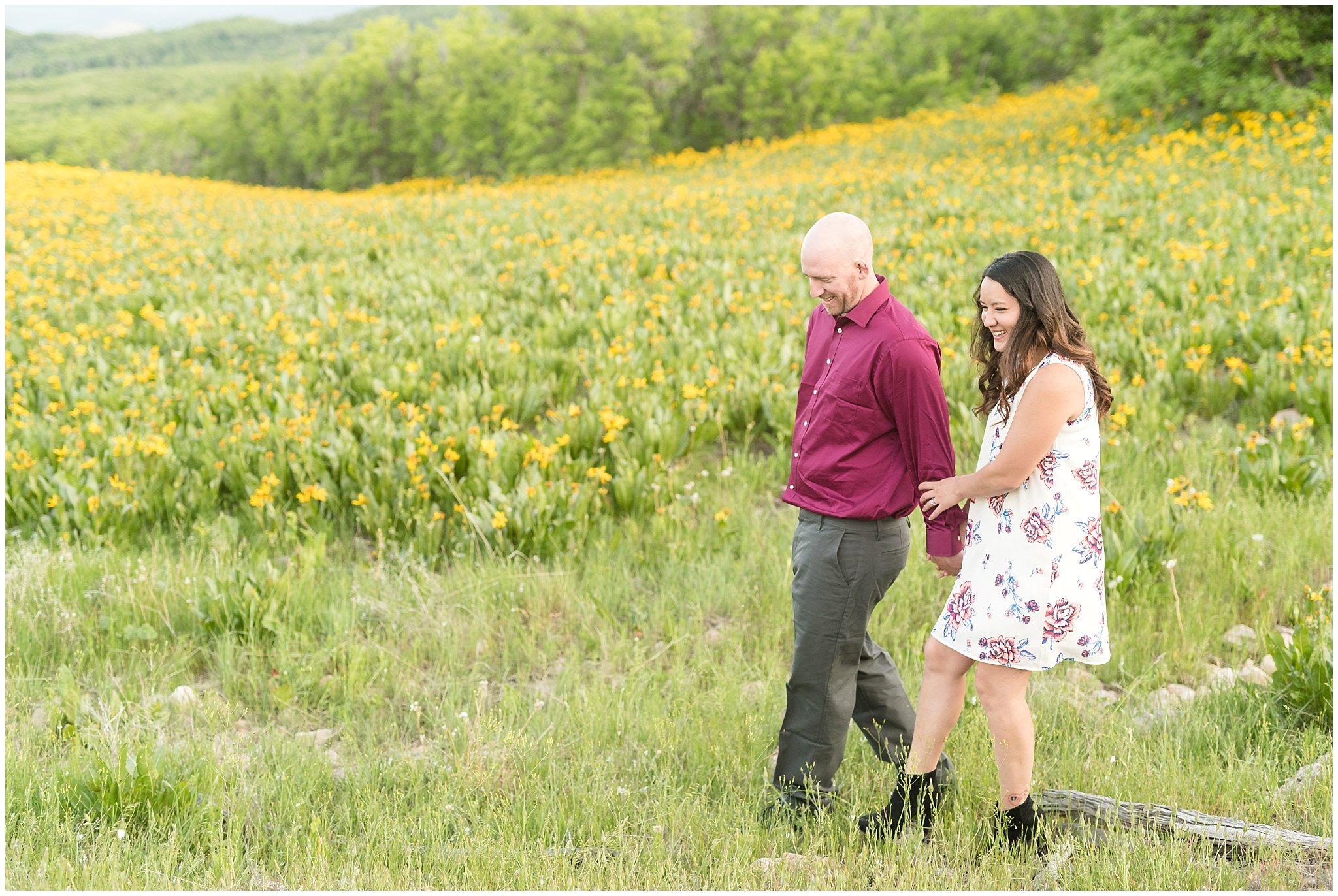 Couple walking during engagement session in the mountains with wildflowers | Snowbasin Utah Engagements