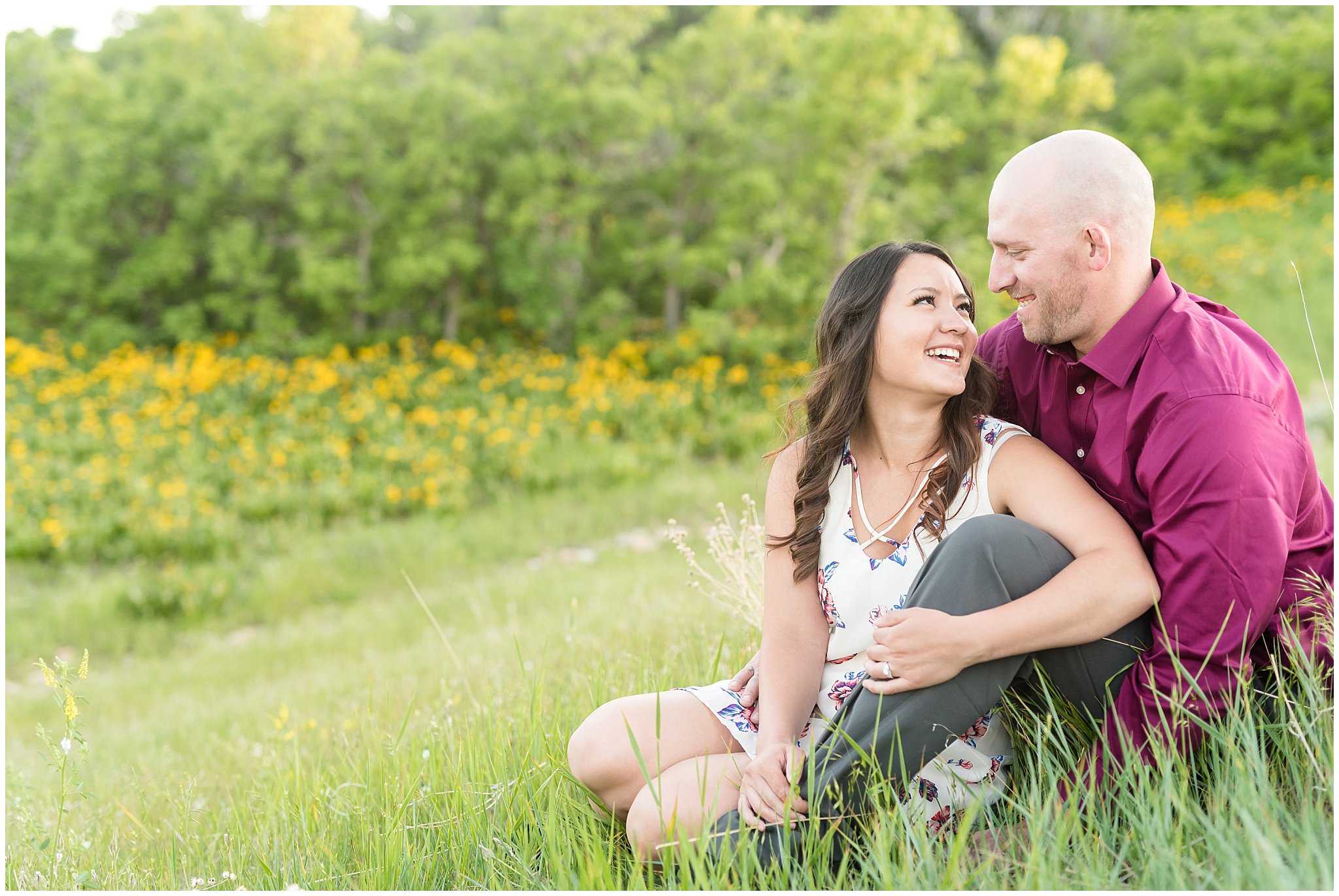 Happy couple engagement session with mountains in the background and wildflowers | Snowbasin Utah Engagements