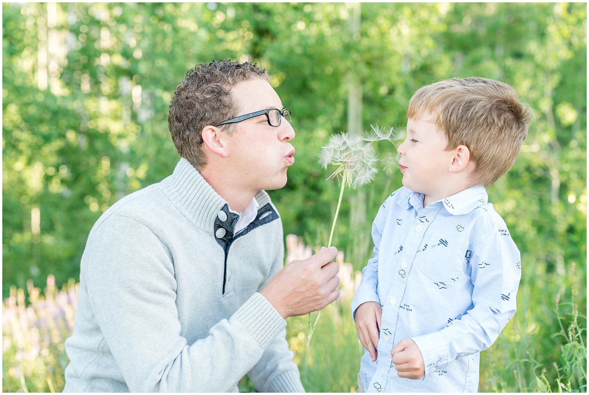 Father and son blowing dandelions in the mountains | Snowbasin Utah