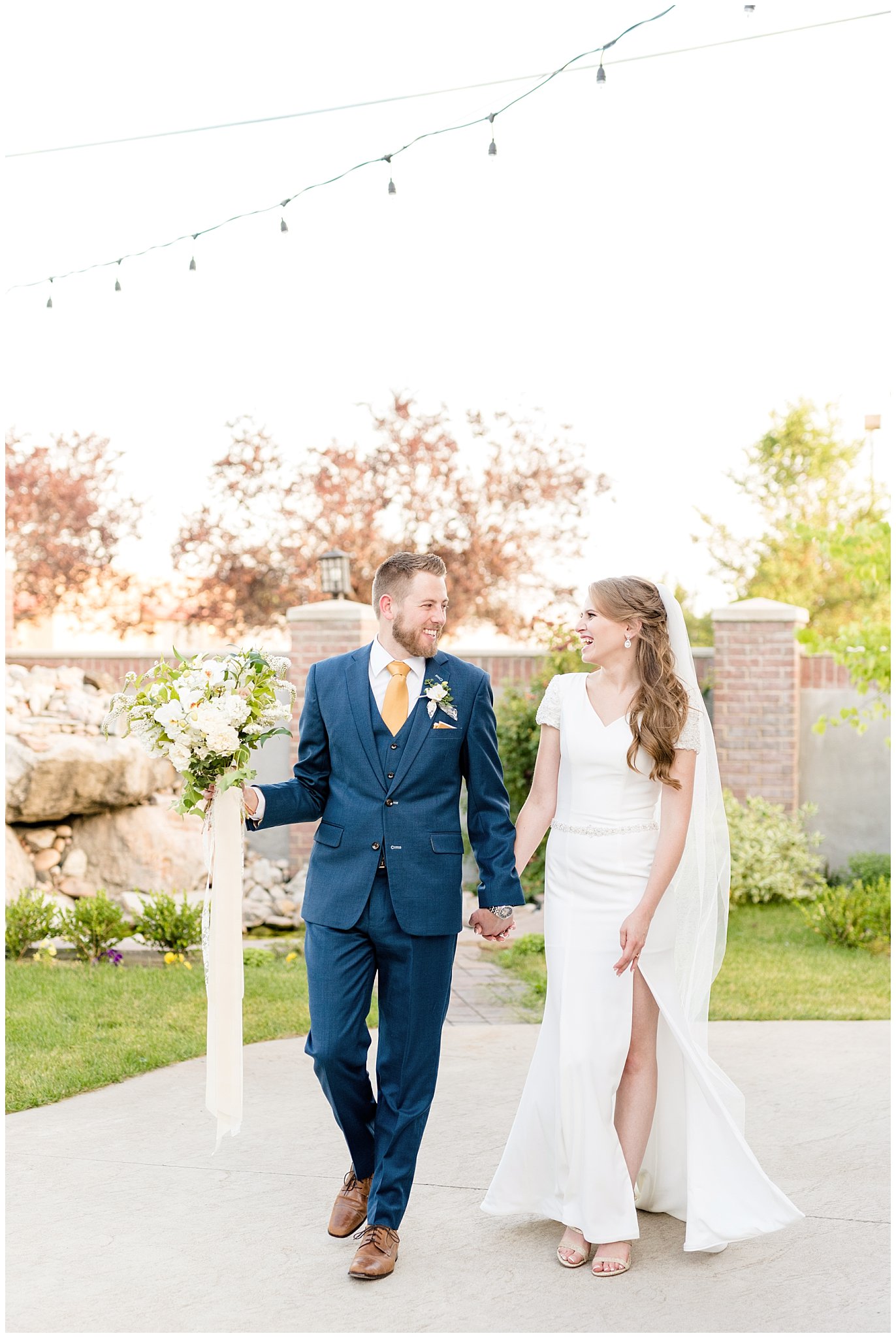 Bride and groom walking and laughing | gold, navy and white wedding | Talia Event Center | Utah Wedding Photography | Jessie and Dallin Photography