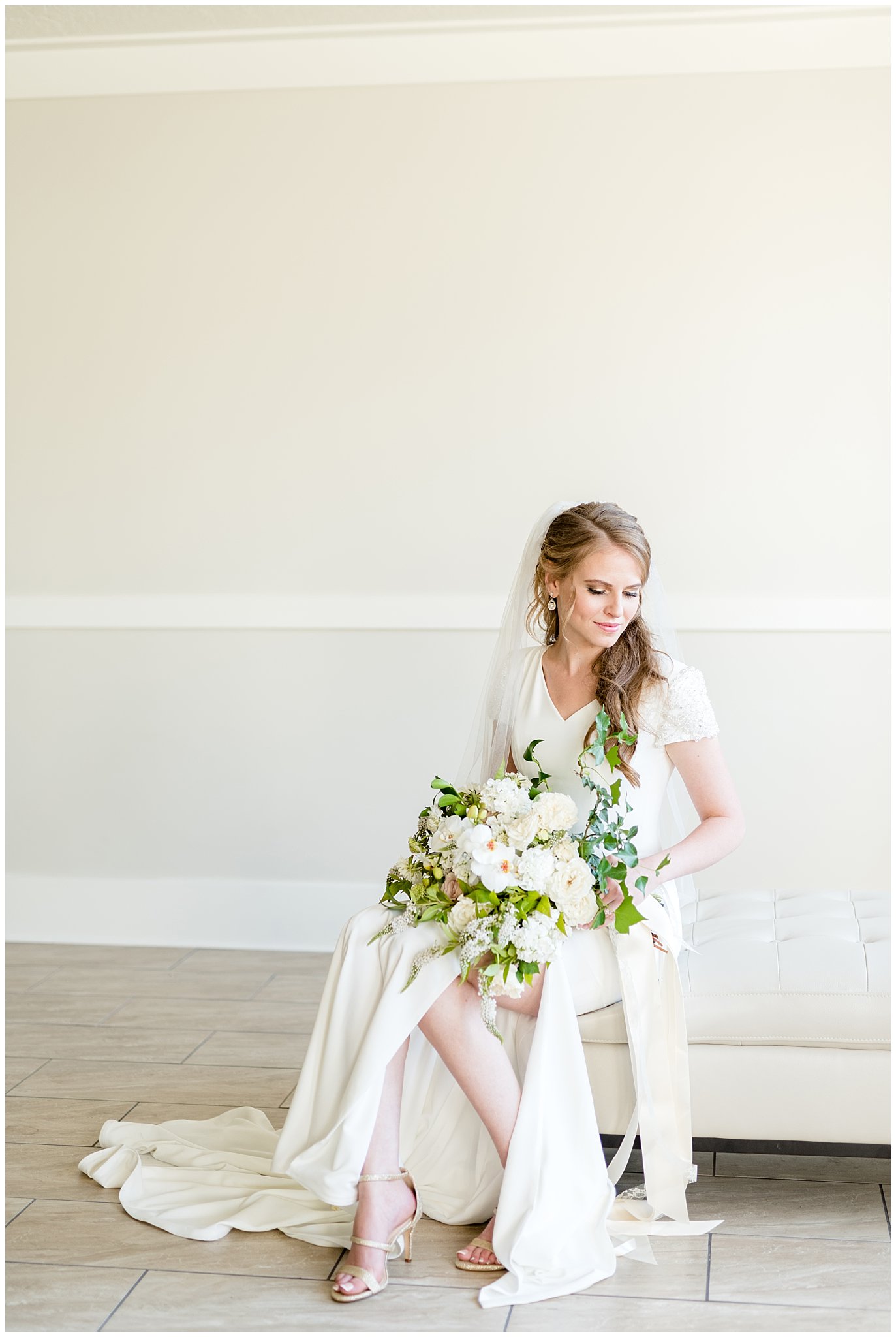 Bright and joyful bridal shot with bouquet. Bride sitting on chair | Talia Event Center
