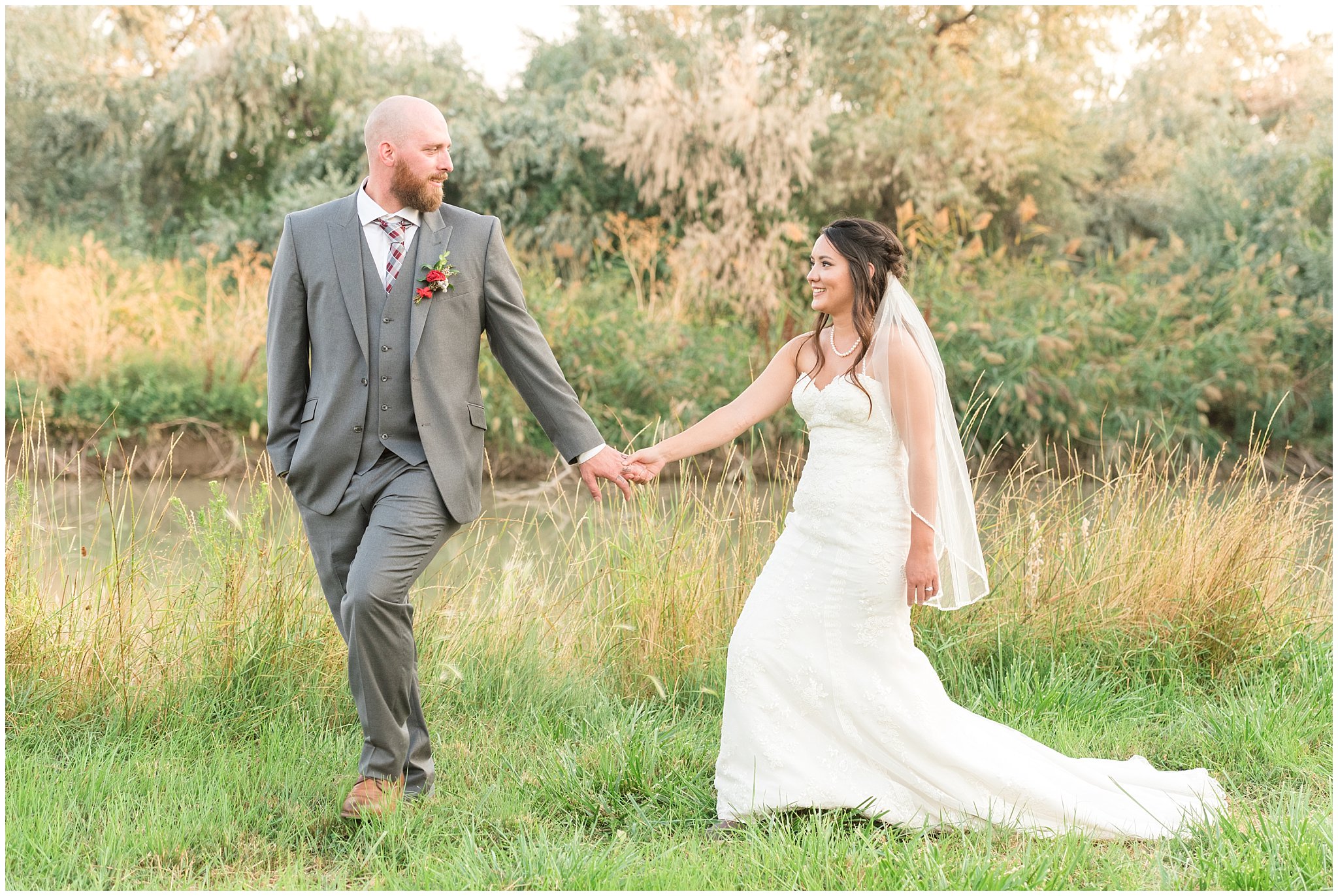 Bride and groom walking in a field during sunset portraits | Red and Grey wedding | Davis County Outdoor Wedding | Jessie and Dallin Photography