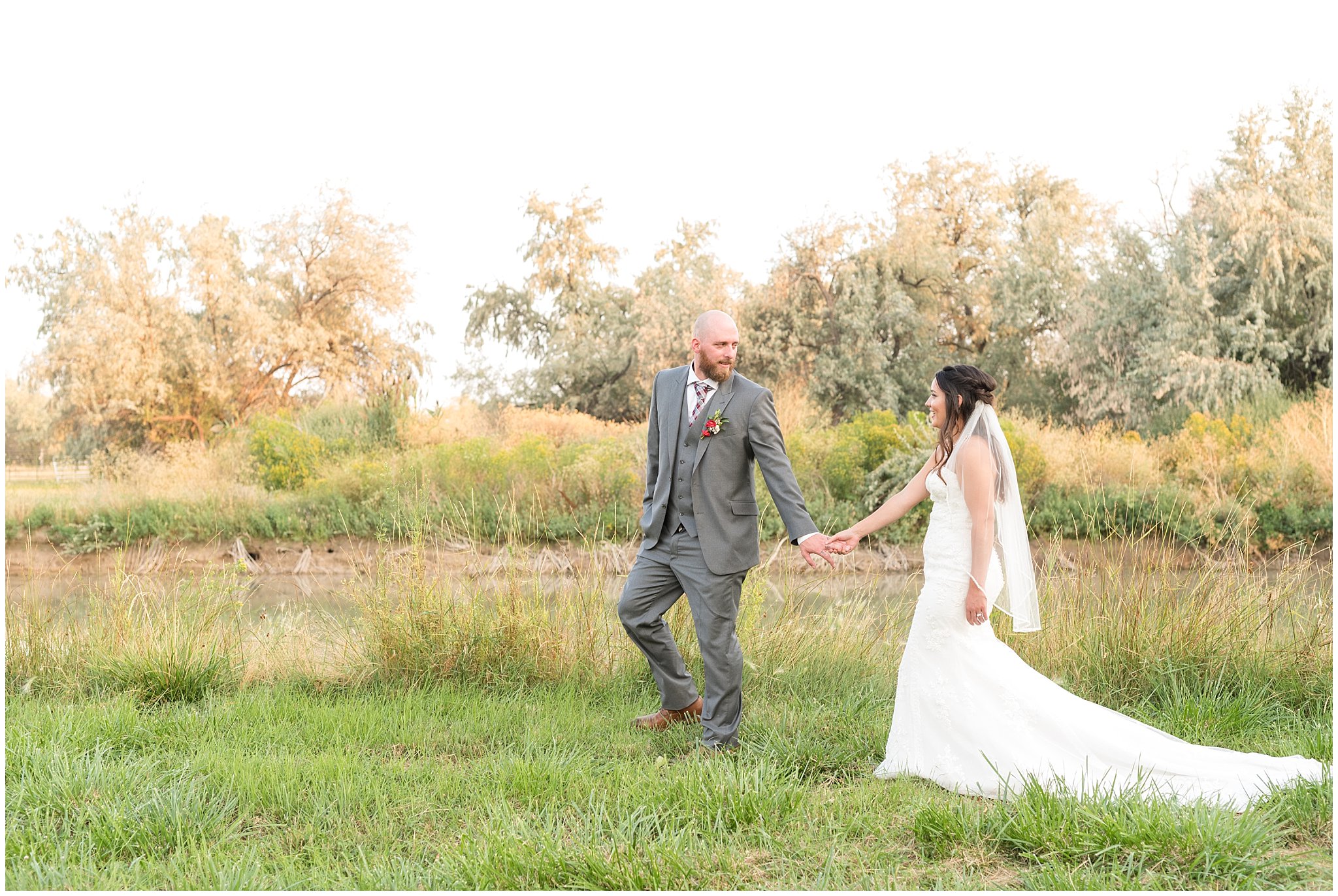 Bride and groom walking together near a pond during sunset portraits | Red and Grey wedding | Davis County Outdoor Wedding | Jessie and Dallin Photography
