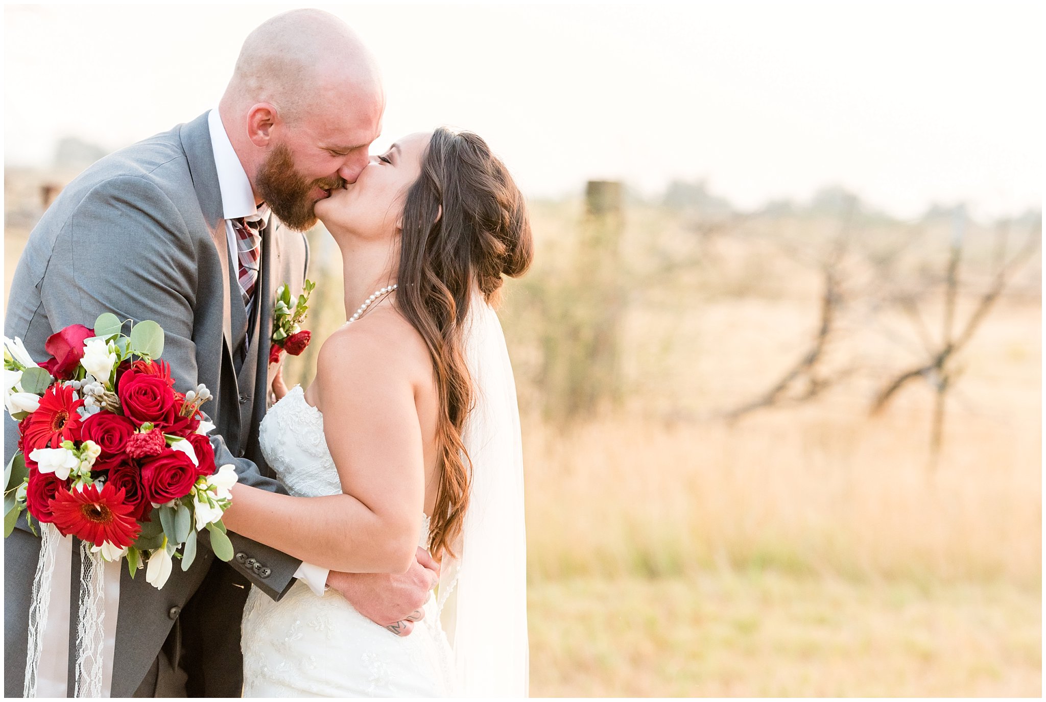 Bride and groom giggle kiss during sunset portraits | Red and Grey wedding | Davis County Outdoor Wedding | Jessie and Dallin Photography