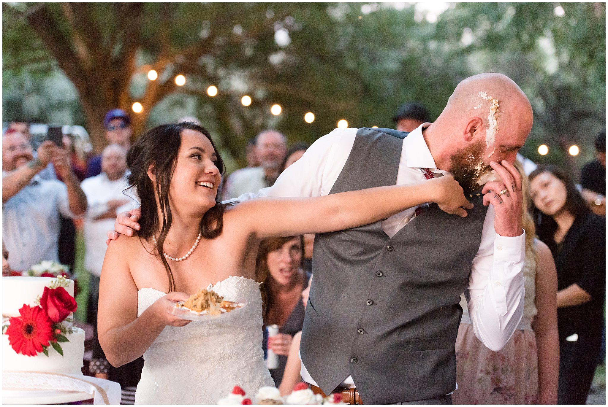 Bride smashes cake in grooms face during cake cutting | Red and Grey wedding | Davis County Outdoor Wedding | Jessie and Dallin Photography
