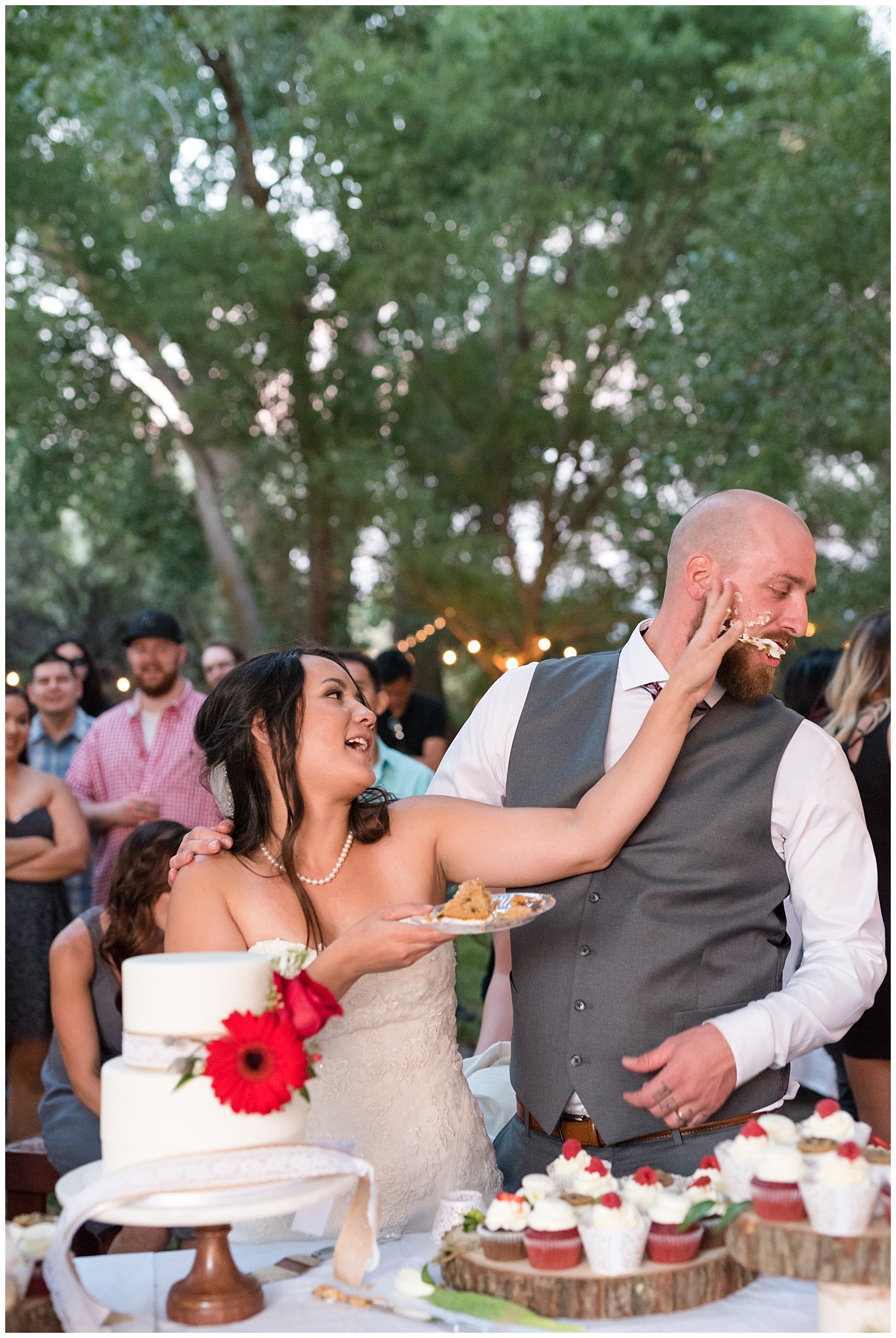 Bride slams cake in grooms face during cake cutting | Red and Grey wedding | Davis County Outdoor Wedding | Jessie and Dallin Photography