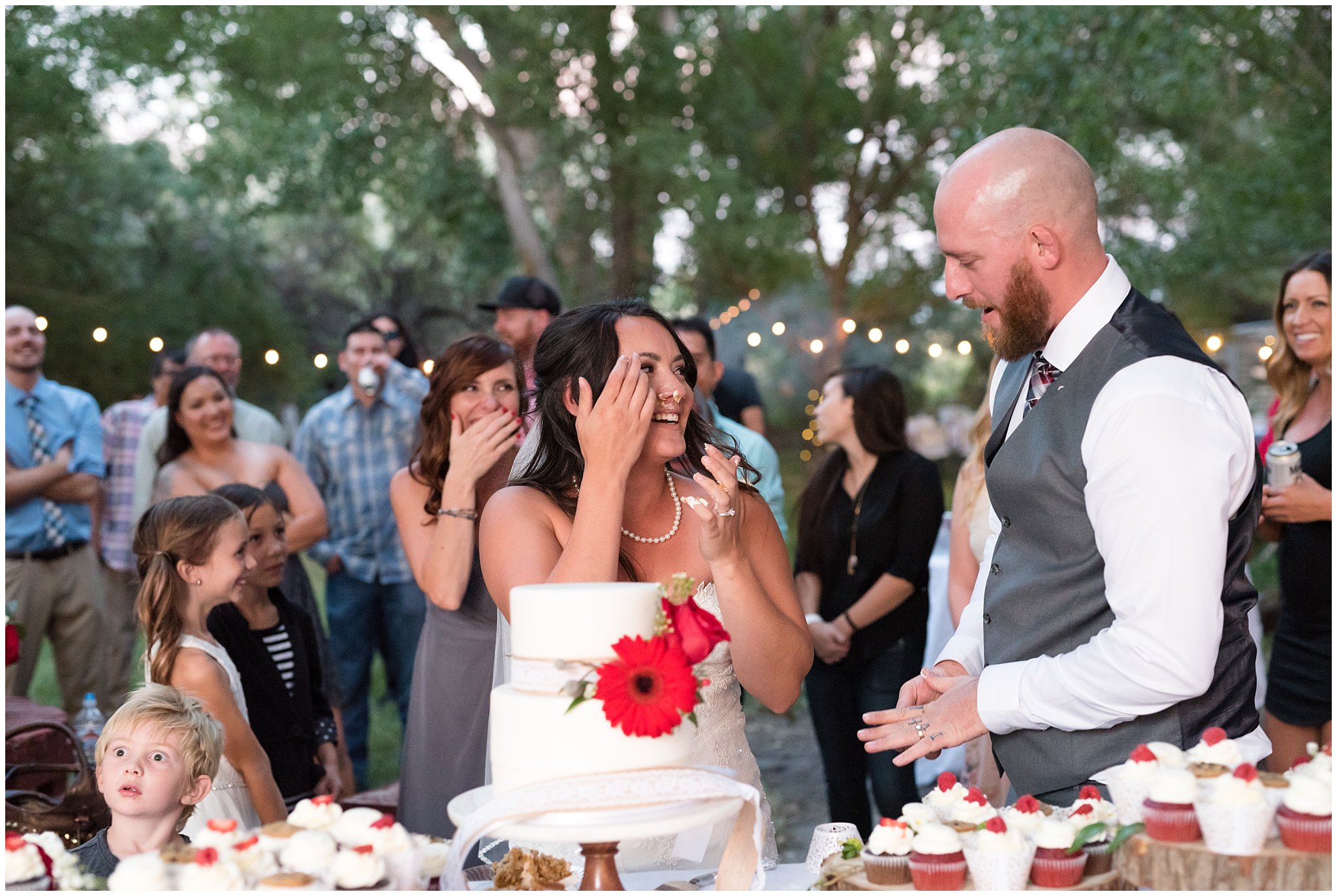 Bride and groom covered in cake during cake cutting | Red and Grey wedding | Davis County Outdoor Wedding | Jessie and Dallin Photography