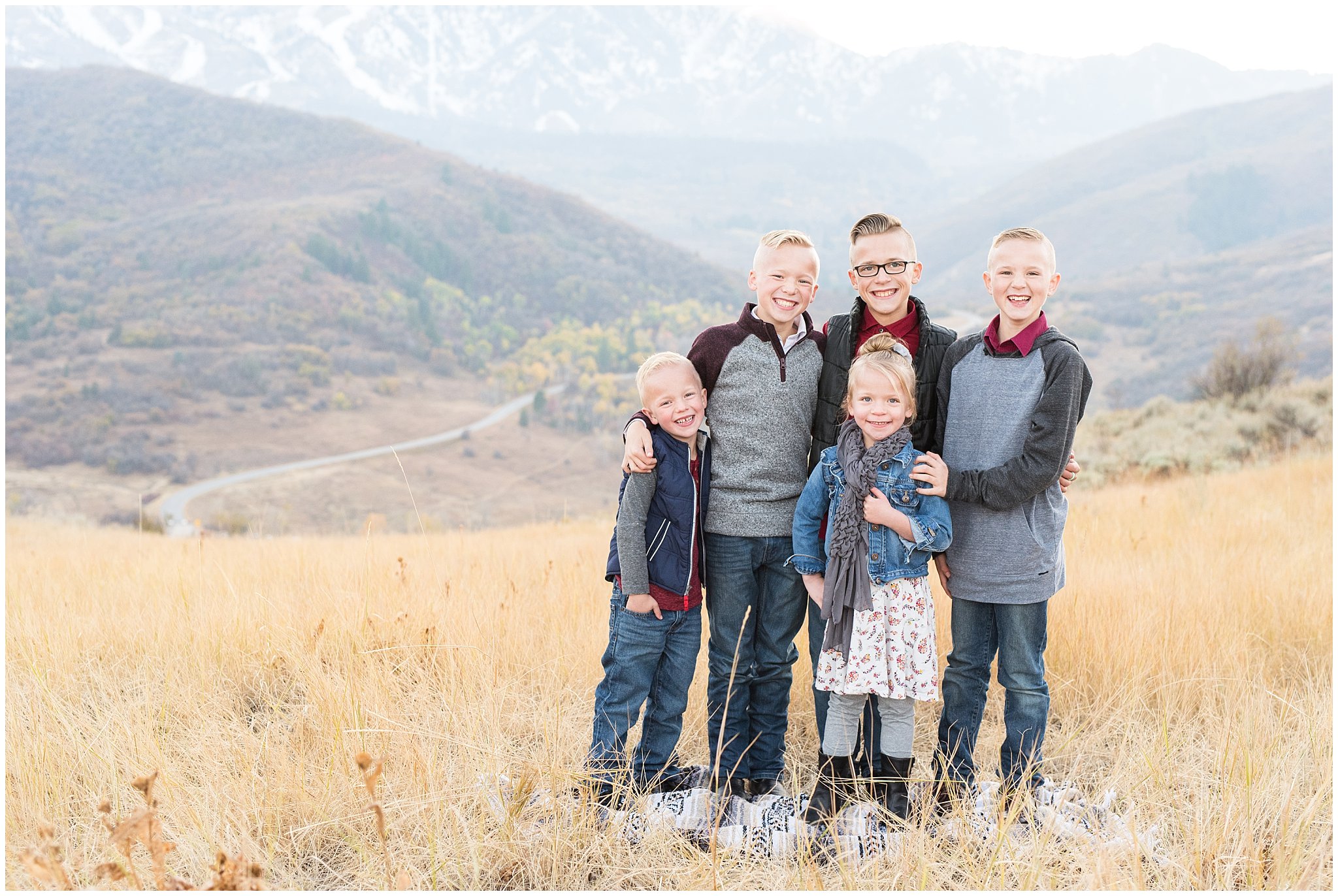 Candid siblings laughing in front of snowy mountains | Fall Family Pictures in the Mountains | Snowbasin, Utah | Jessie and Dallin Photography