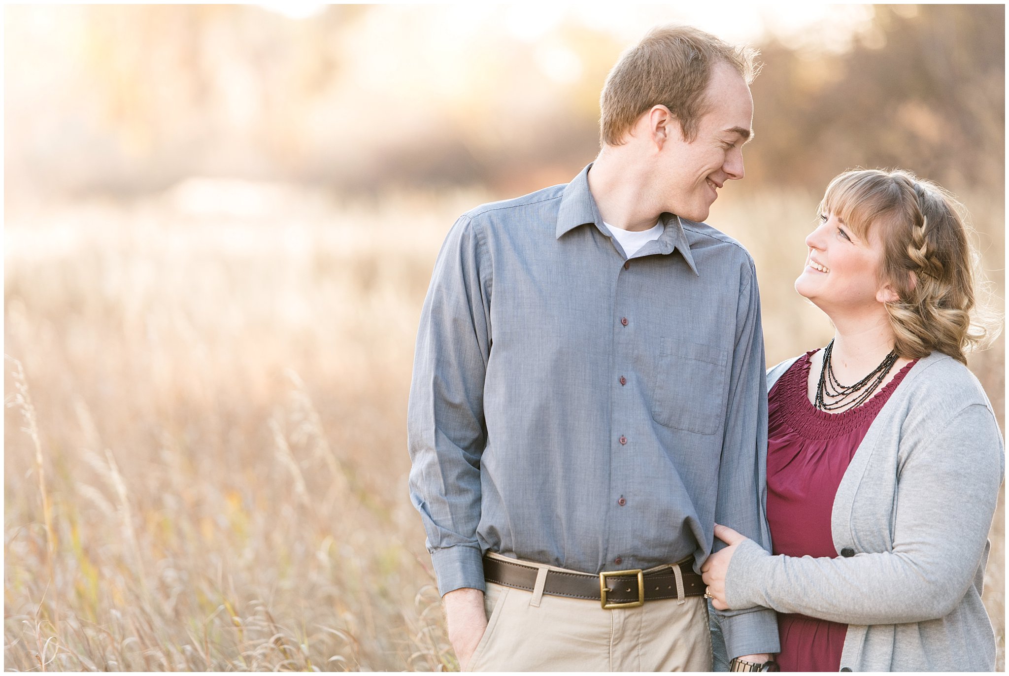 Couple smiling at each other in a field | Davis County Fall Engagement | Utah Wedding Photographers | Jessie and Dallin