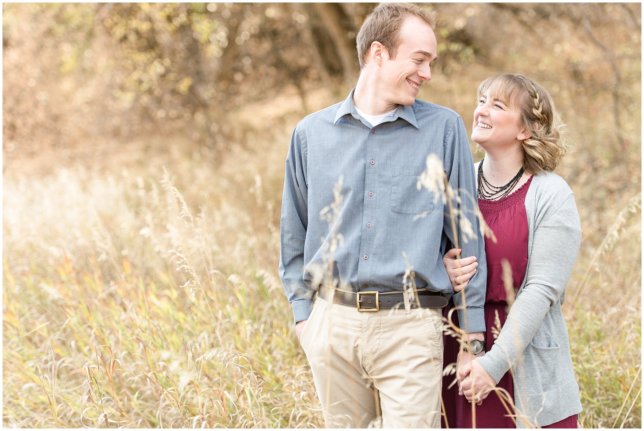 Couple laughs with each other in a field | Davis County Fall Engagement | Utah Wedding Photographers | Jessie and Dallin