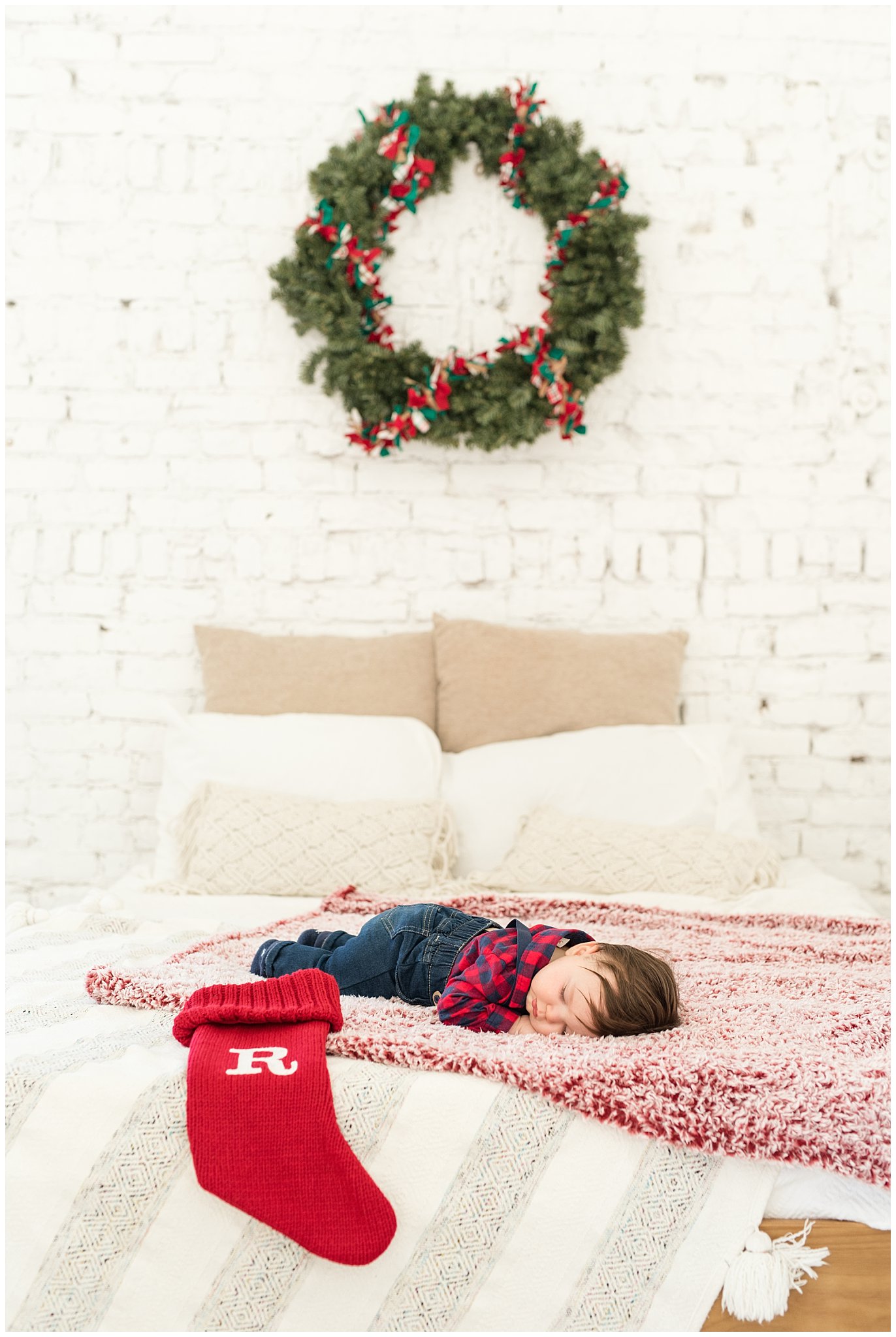 Sleeping 6 month old baby boy on bed with Christmas stocking and wreath | Family Christmas session at the 5th floor | Utah Photographers | Jessie and Dallin Photography