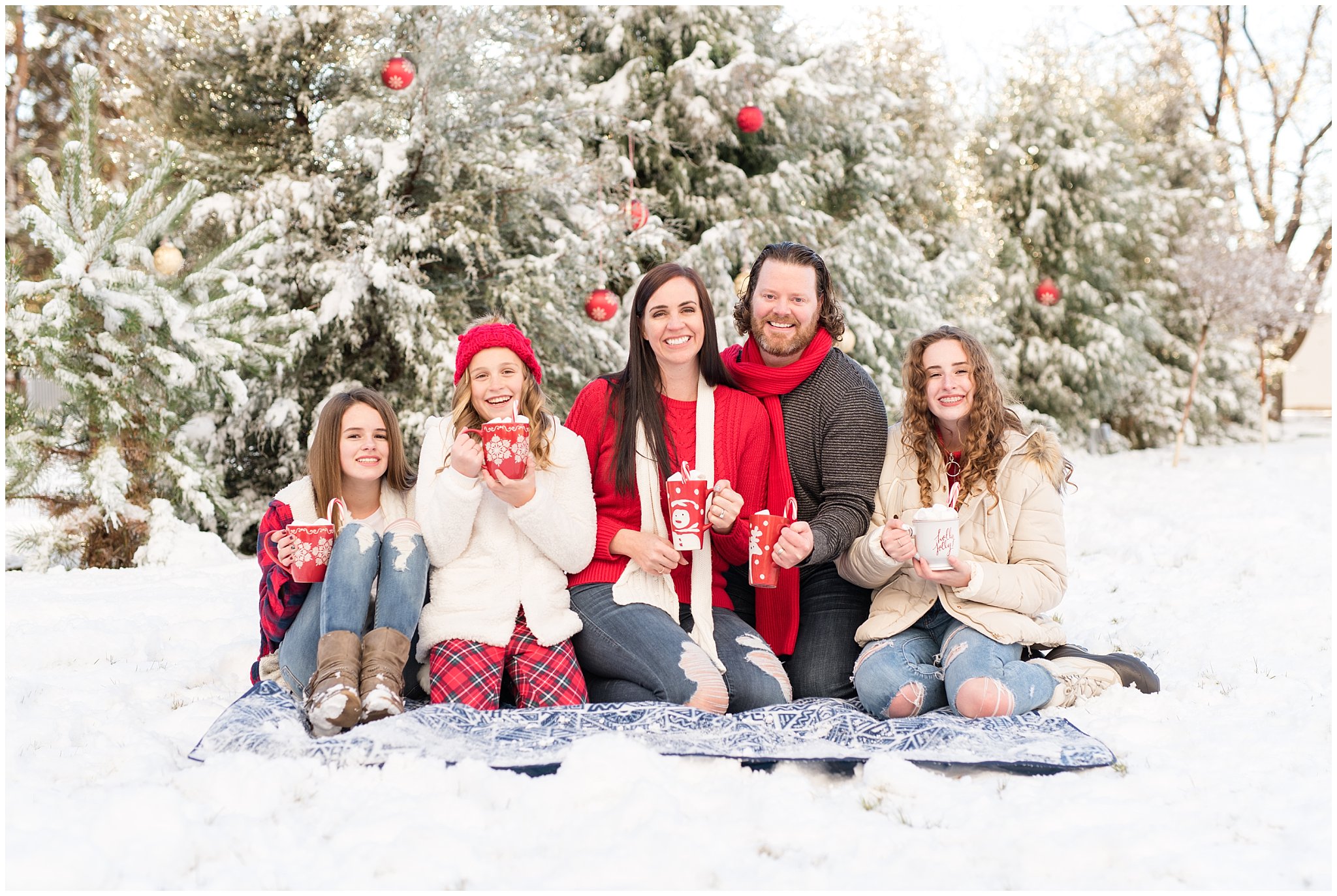 Family with hot chocolate mugs in front of Christmas trees in the snow | Utah Family Christmas Photoshoot | Oak Hills Reception and Event | Jessie and Dallin Photography