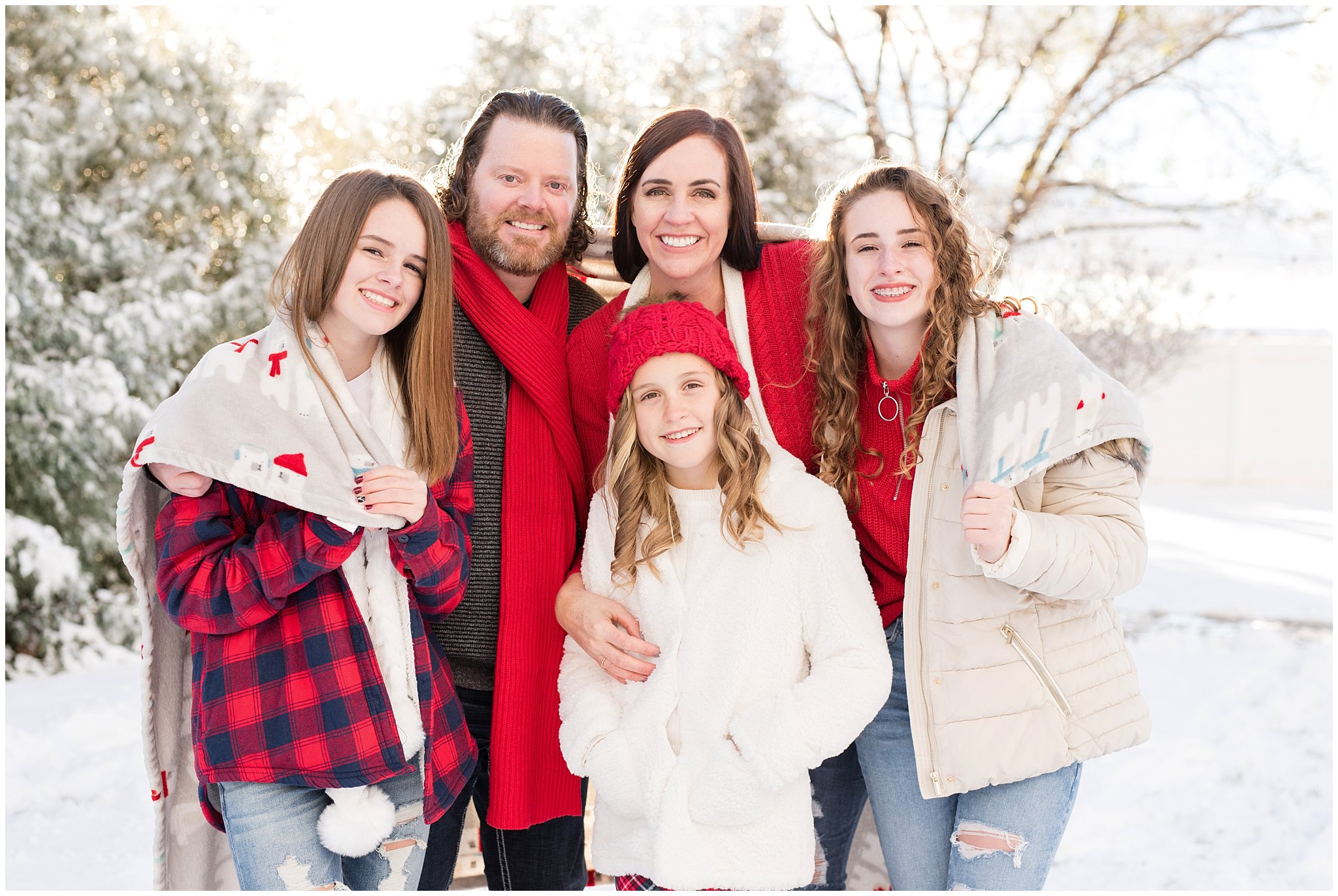 Family wrapped in blanket in the snow standing in front of Christmas trees | Utah Family Christmas Photoshoot | Oak Hills Reception and Event | Jessie and Dallin Photography