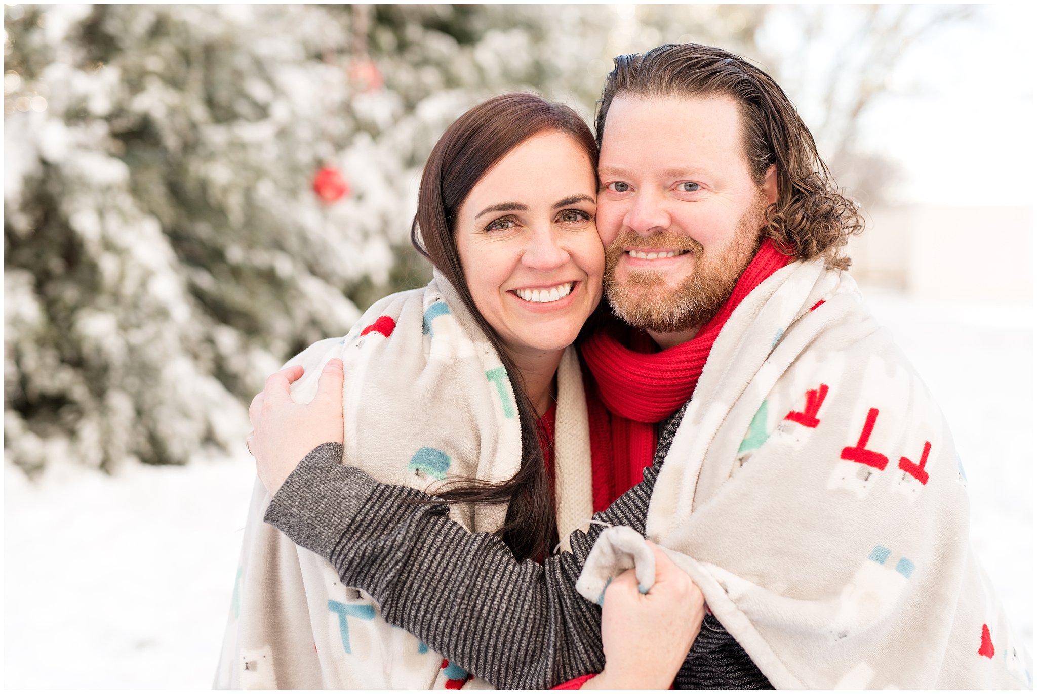 Couple wrapped in blanket sitting in the snow | Utah Family Christmas Photoshoot | Oak Hills Reception and Event | Jessie and Dallin Photography