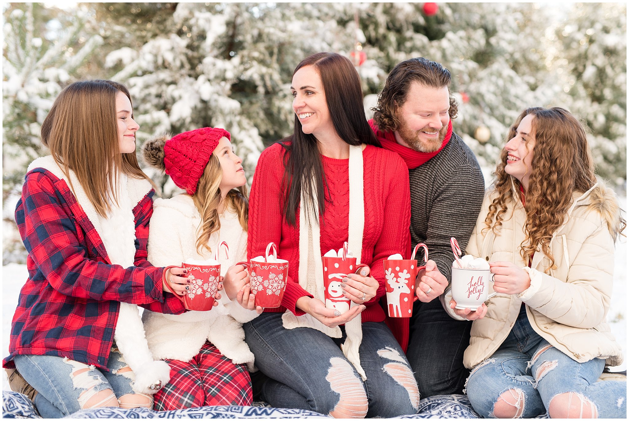 Family holding hot chocolate laughing at each other in front of Christmas trees | Utah Family Christmas Photoshoot | Oak Hills Reception and Event | Jessie and Dallin Photography
