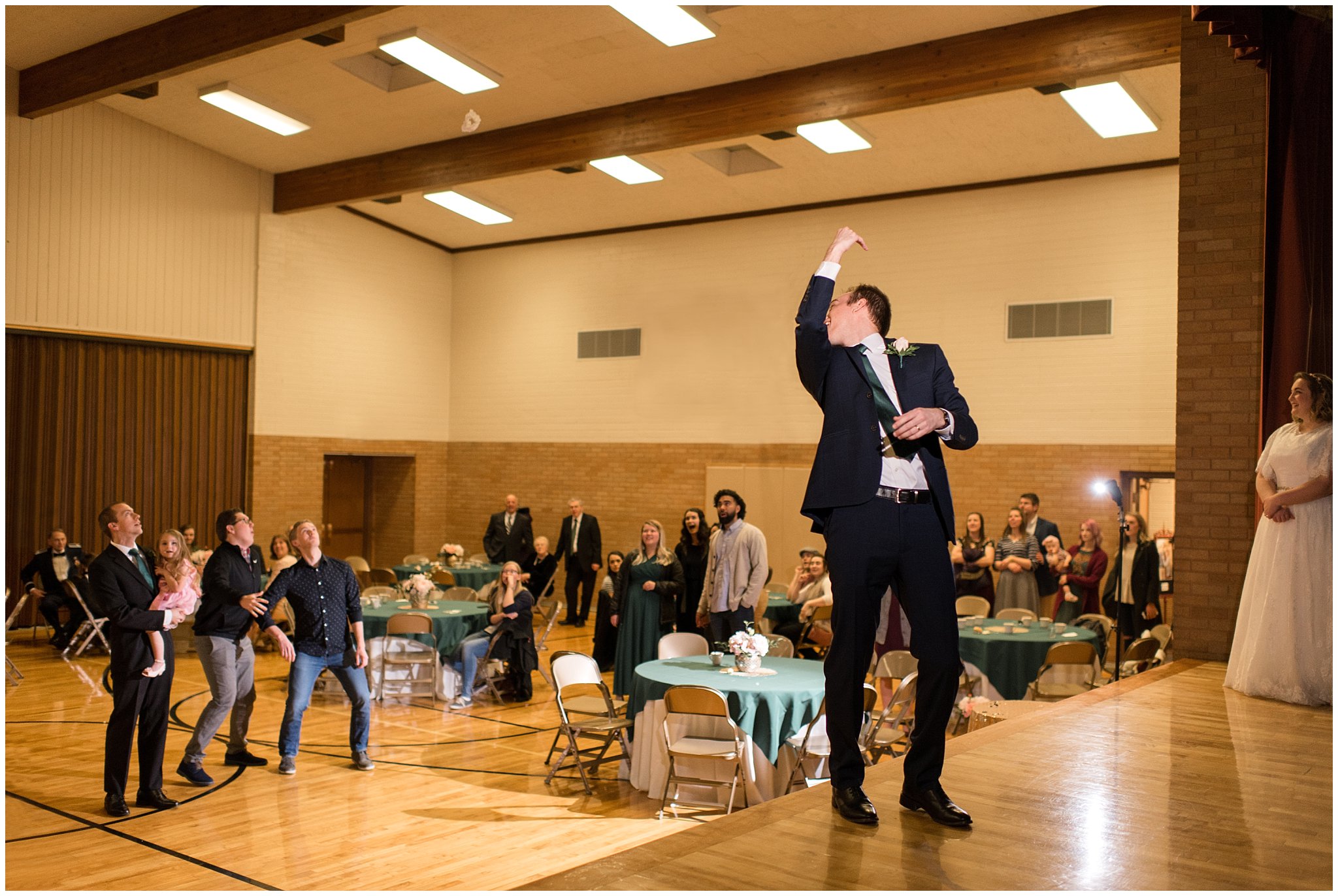 Groom tosses garter off the stage | Ogden Temple Winter Wedding | Emerald Green and Pink Wedding | Jessie and Dallin Photography