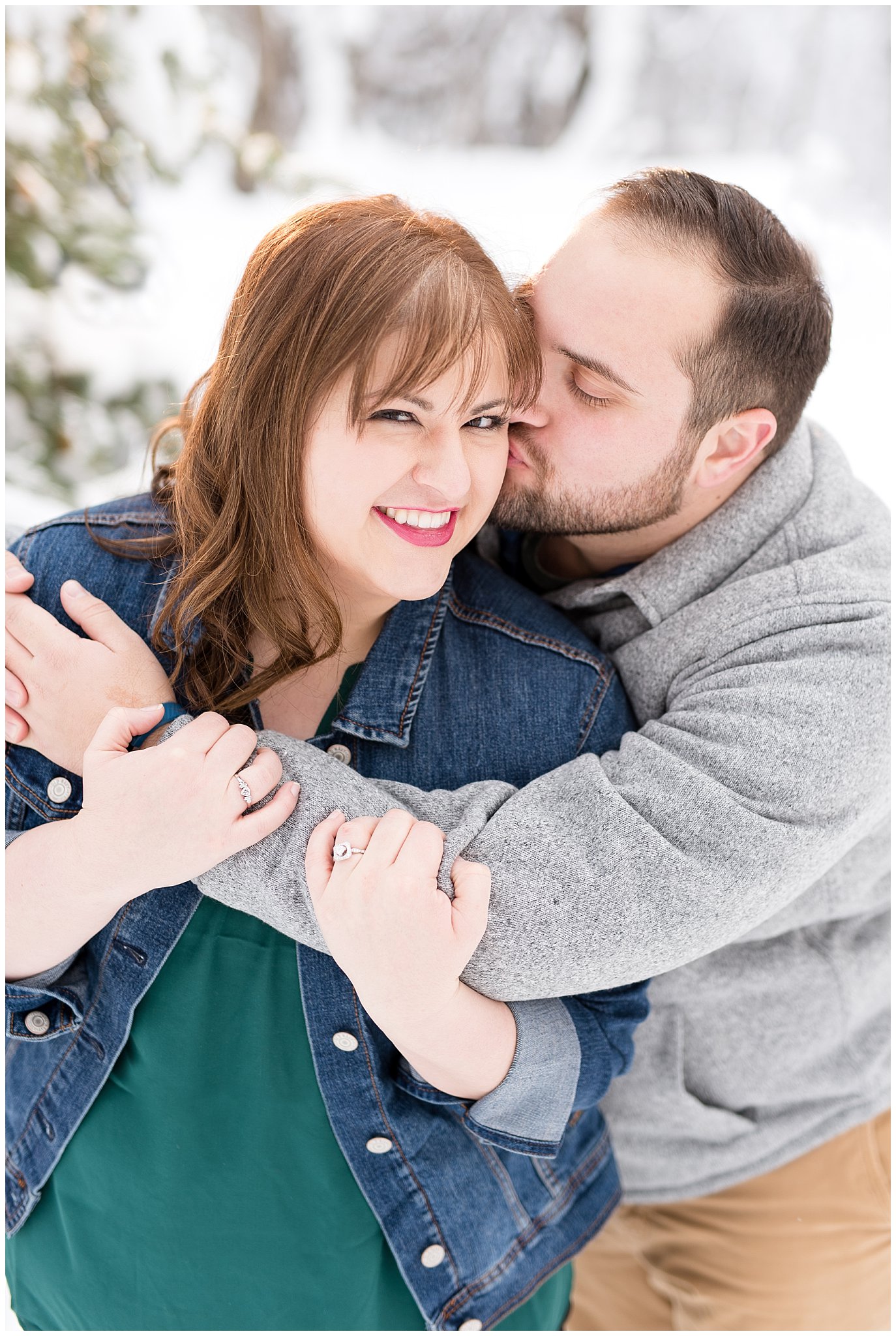 Couple laughing in front of snowy pine tree |  Winter Engagement at Mueller Park and the Utah State Capitol | Jessie and Dallin Photography