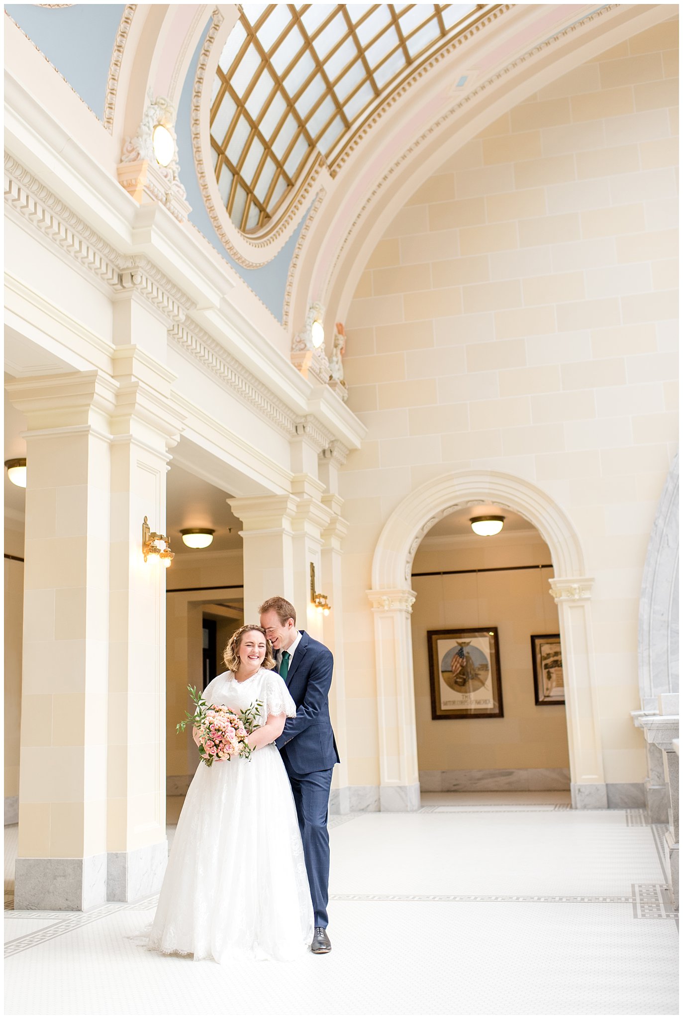 Bride and groom cuddled close under capitol building windows | Winter Formals at the Utah State Capitol | Utah Wedding Photography