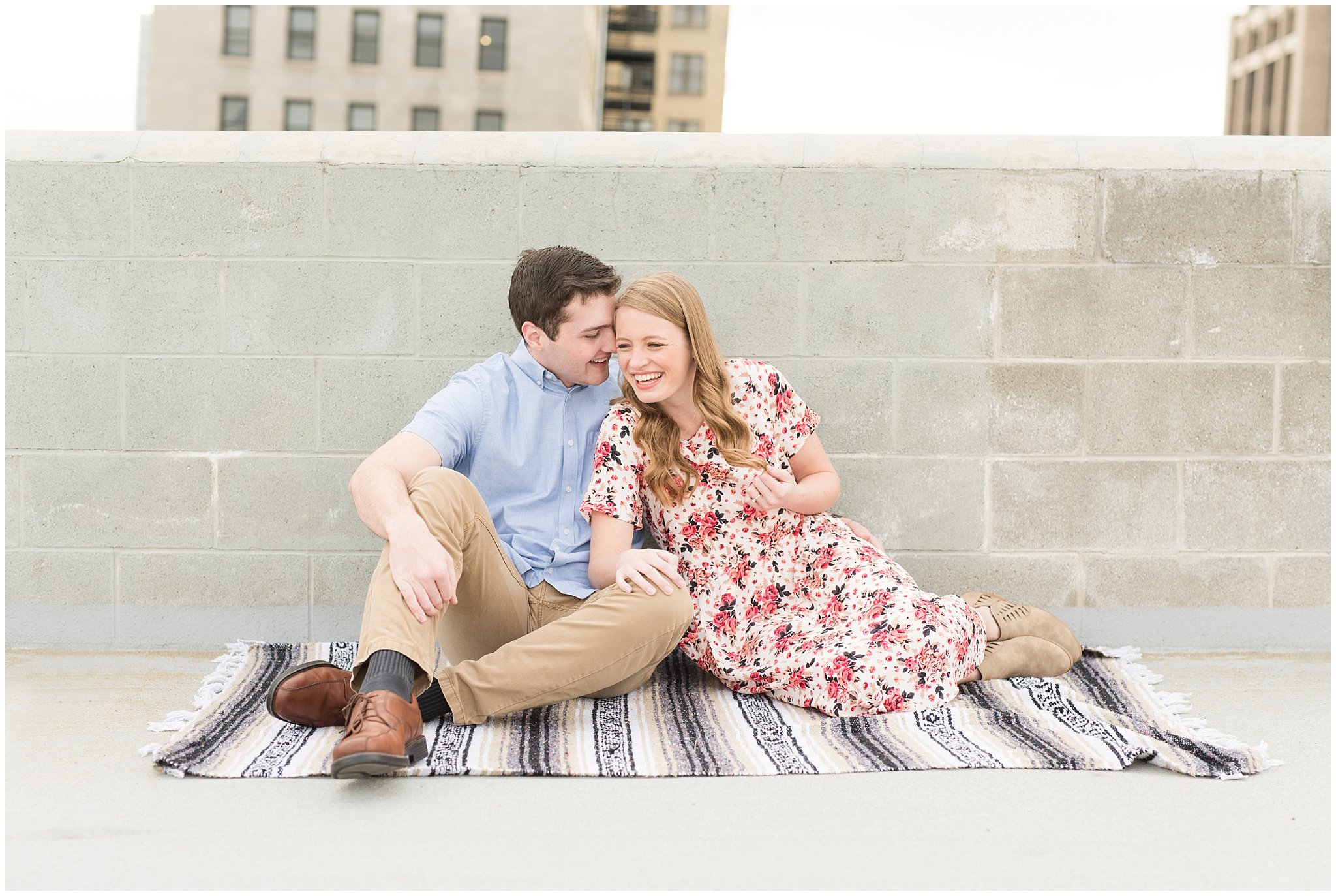Couple snuggled on rooftop | Downtown Salt Lake and Ensign Peak Engagement | Utah Wedding Photographers | Jessie and Dallin Photography