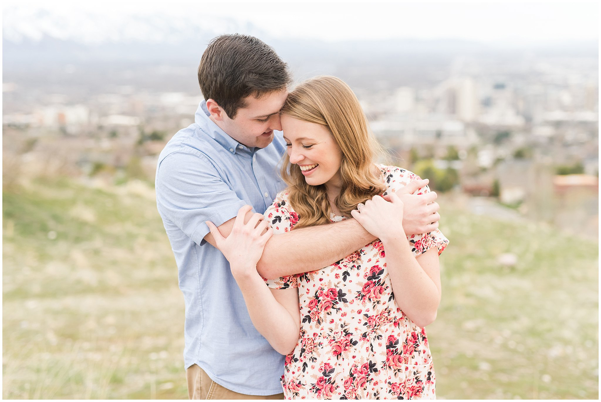 Couple on mountain overlooking city | Downtown Salt Lake and Ensign Peak Engagement | Utah Wedding Photographers | Jessie and Dallin Photography