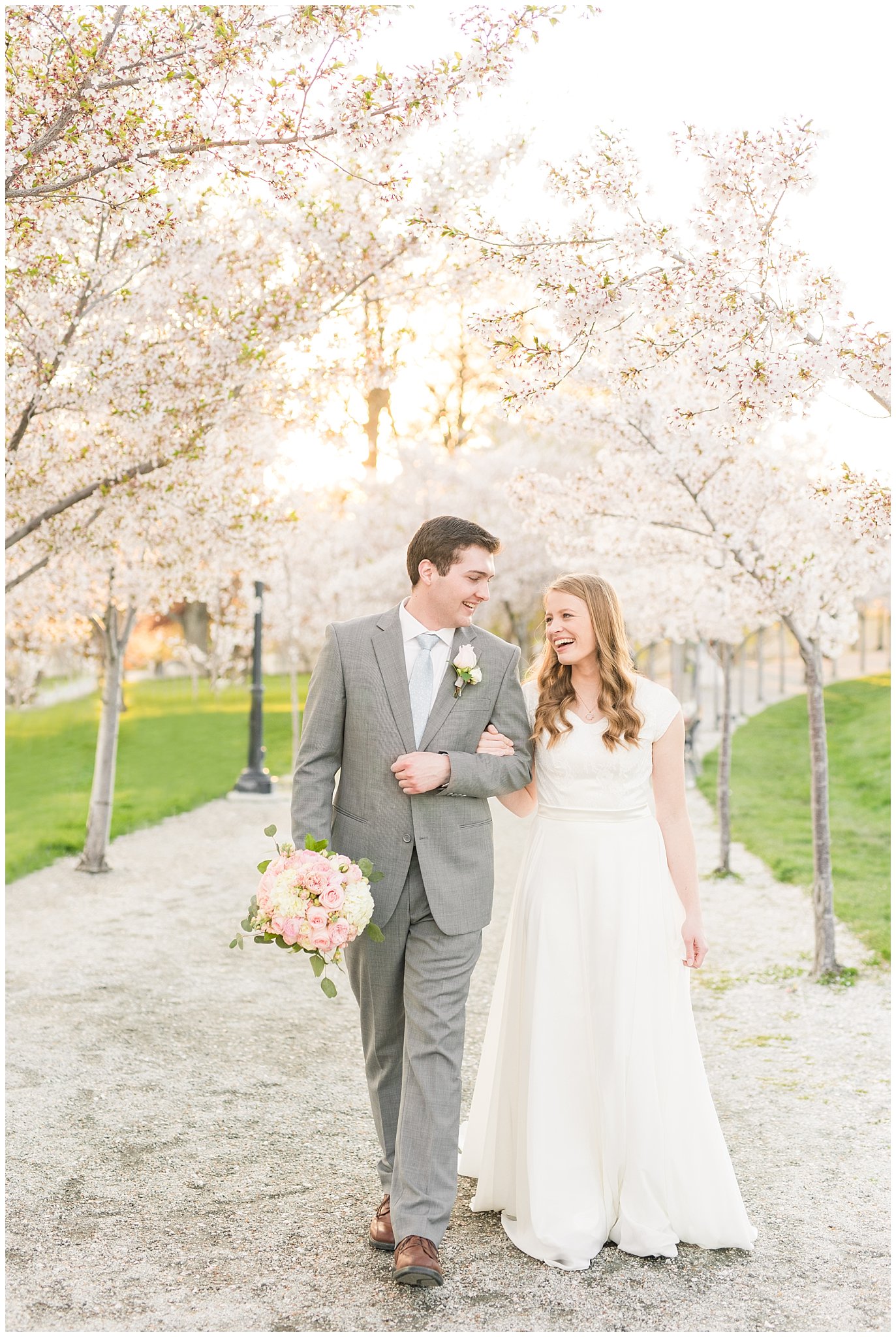 Walking bride with blush bouquet and groom with grey suit in the cherry blossoms | Utah State Capitol Blossoms Formal Session | Salt Lake Wedding Photographers | Jessie and Dallin Photography