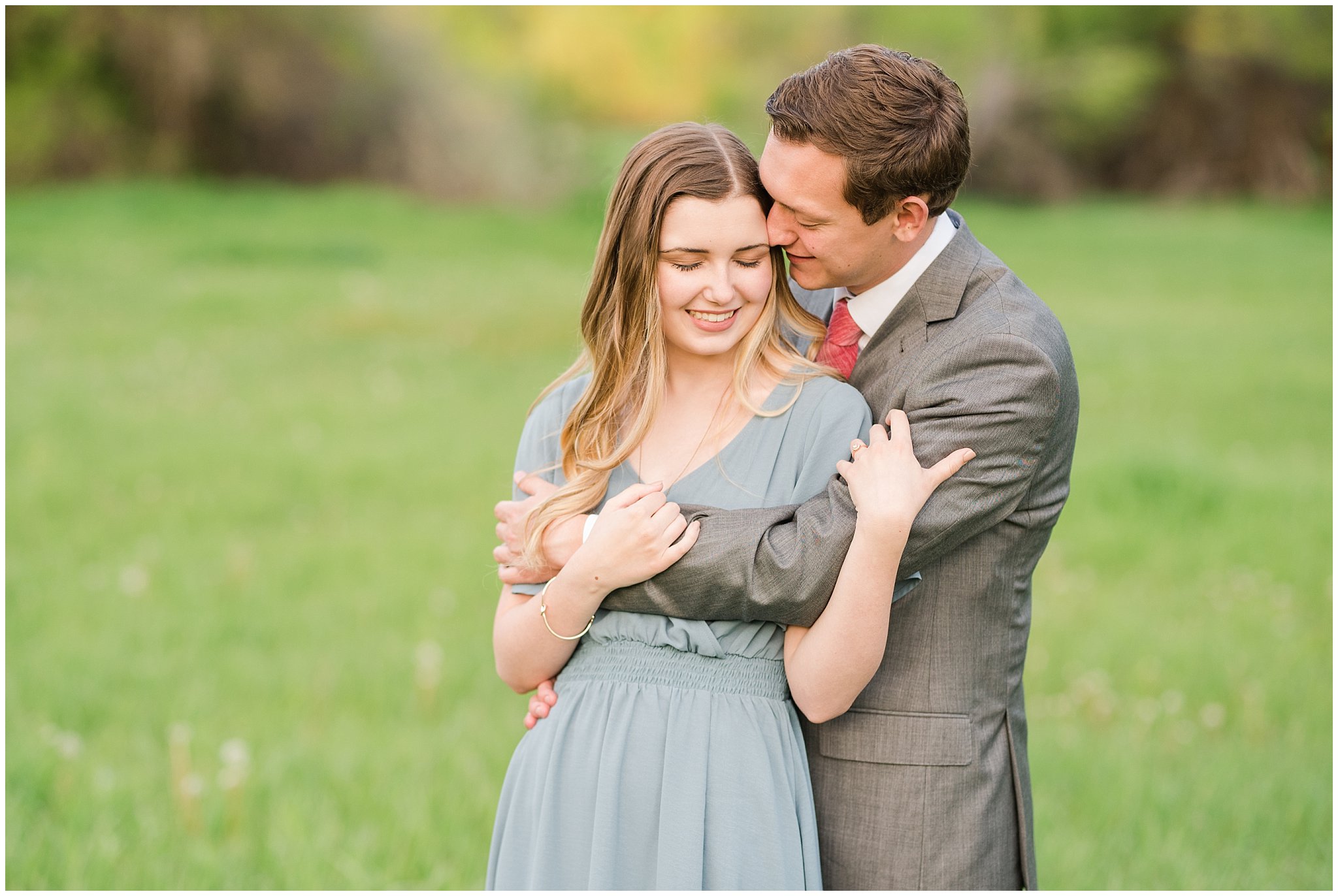 Couple dressed up in flowy blue dress and grey suit for engagement in the woods | Utah Engagement | Jessie and Dallin Photography