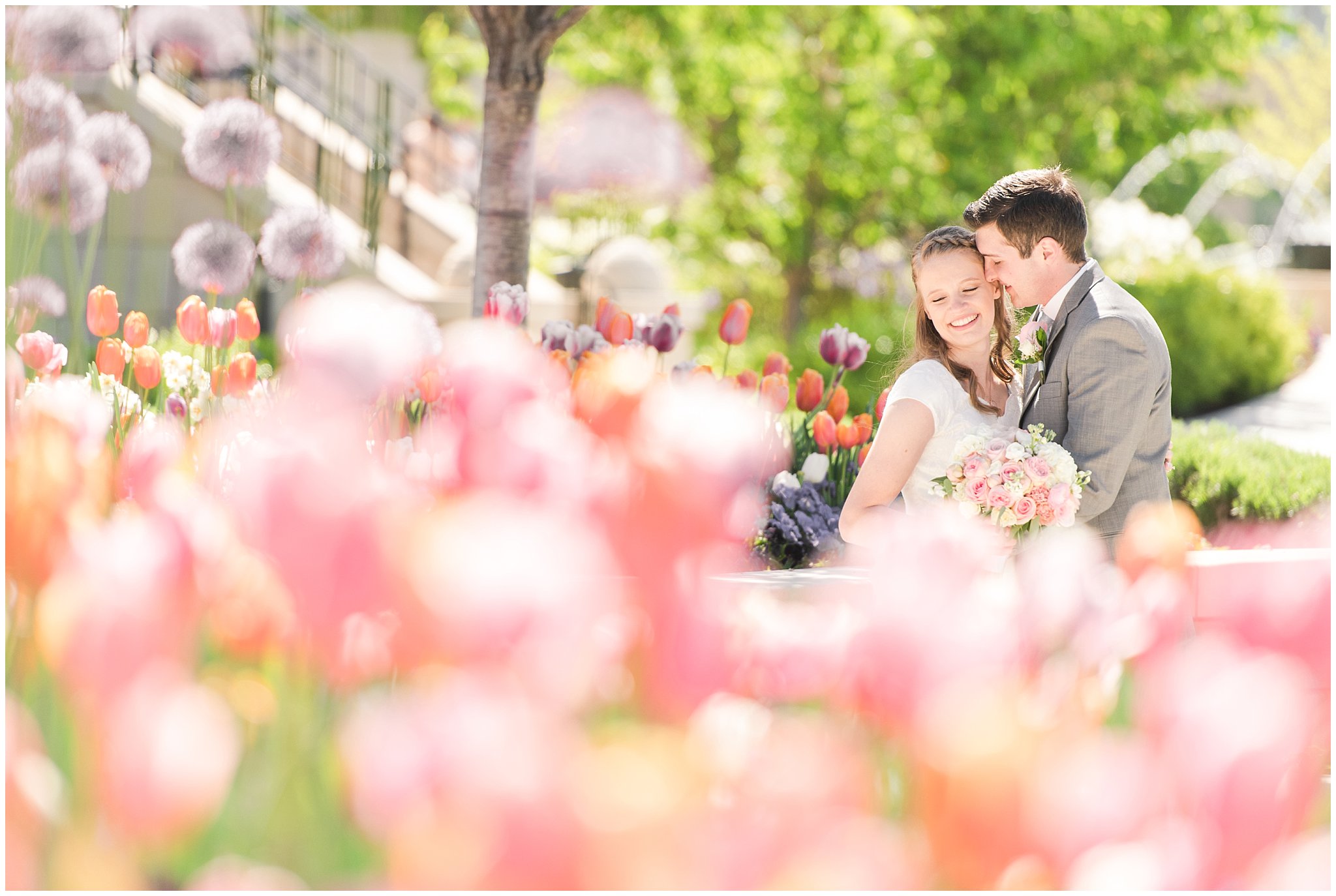 Bride and groom in tulips at Provo City Center temple with grey, blush, and light blue wedding colors | Spring Provo City Center Temple Wedding | Utah Wedding Photographers | Jessie and Dallin Photography