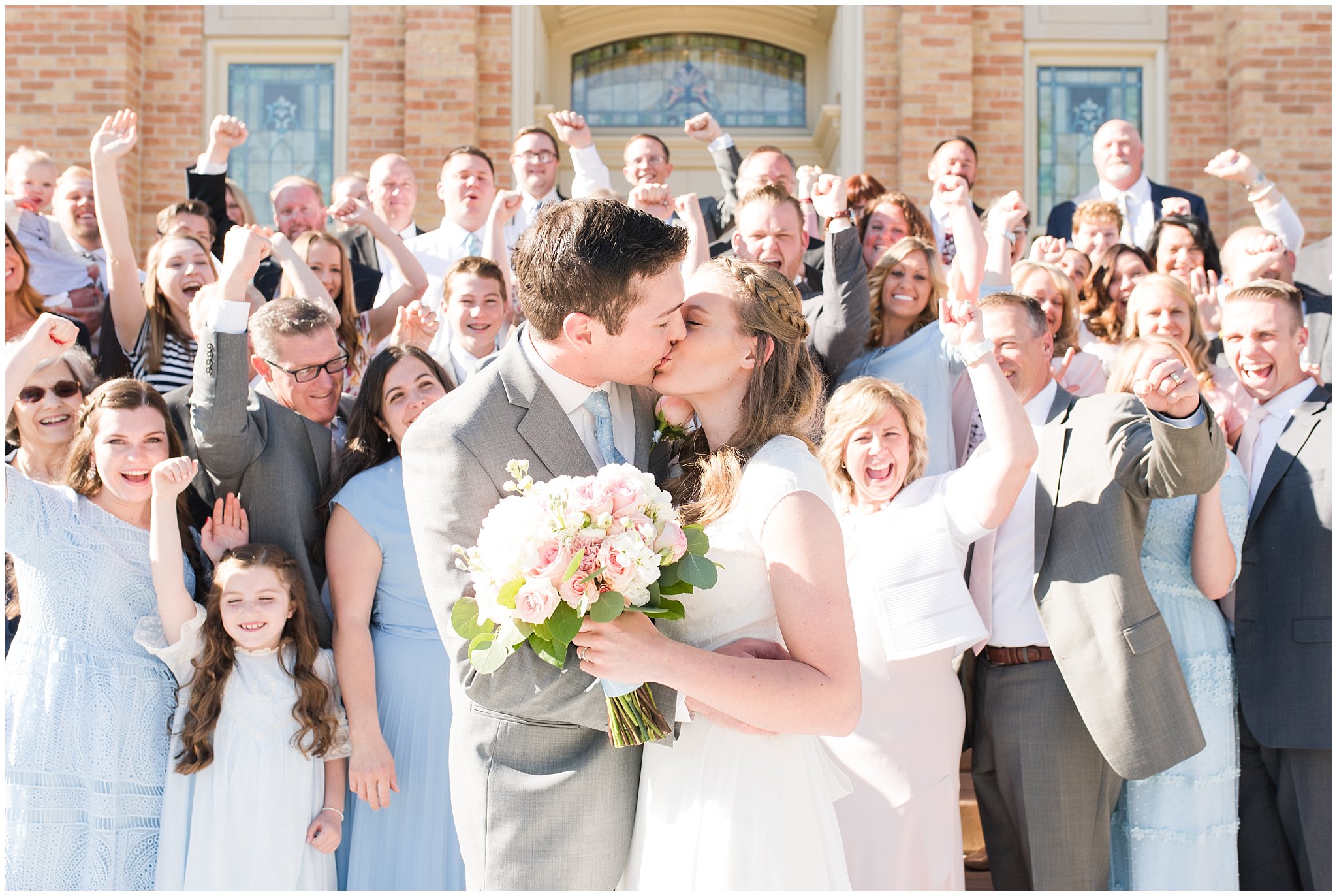 Bride and groom kiss in front of family at Provo City Center temple with grey, blush, and light blue wedding colors | Spring Provo City Center Temple Wedding | Utah Wedding Photographers | Jessie and Dallin Photography