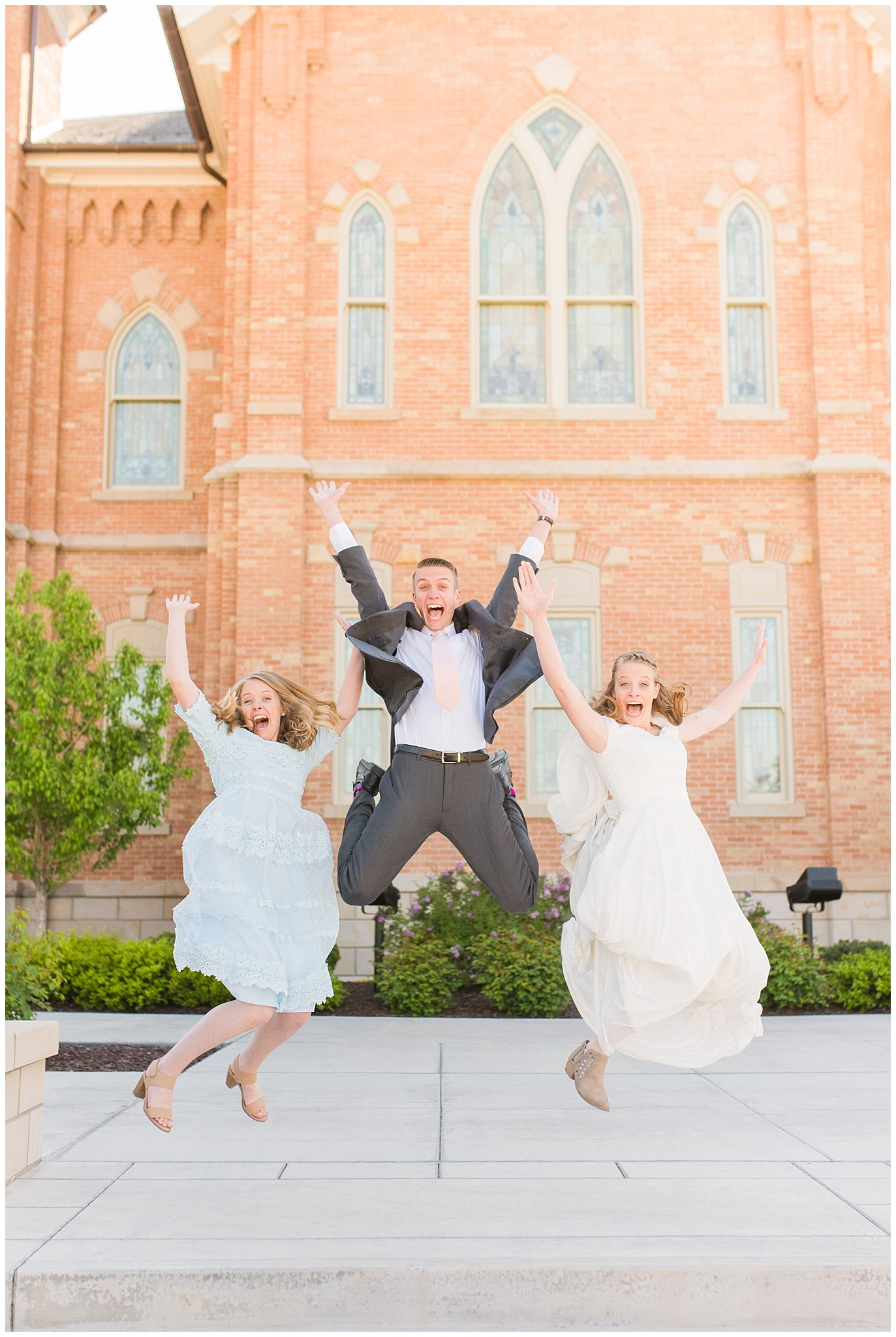 Jumping in the air at Provo City Center temple with grey, blush, and light blue wedding colors | Spring Provo City Center Temple Wedding | Utah Wedding Photographers | Jessie and Dallin Photography