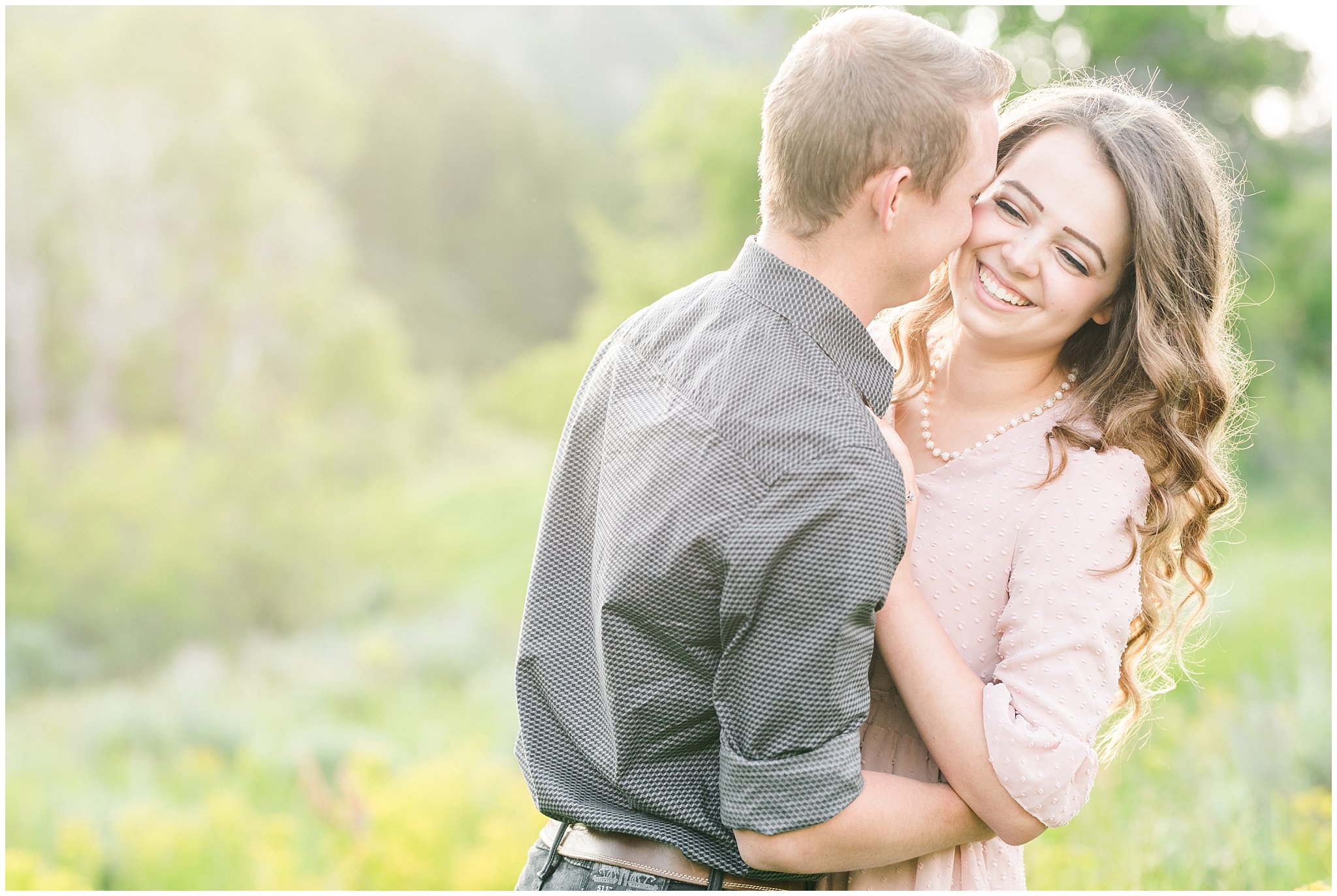 Couple in blush dress and grey and black buttoned shirt in a wooded meadow | Trapper's Loop Mountain Engagement | Utah Mountain Engagement Session | Jessie and Dallin Photography