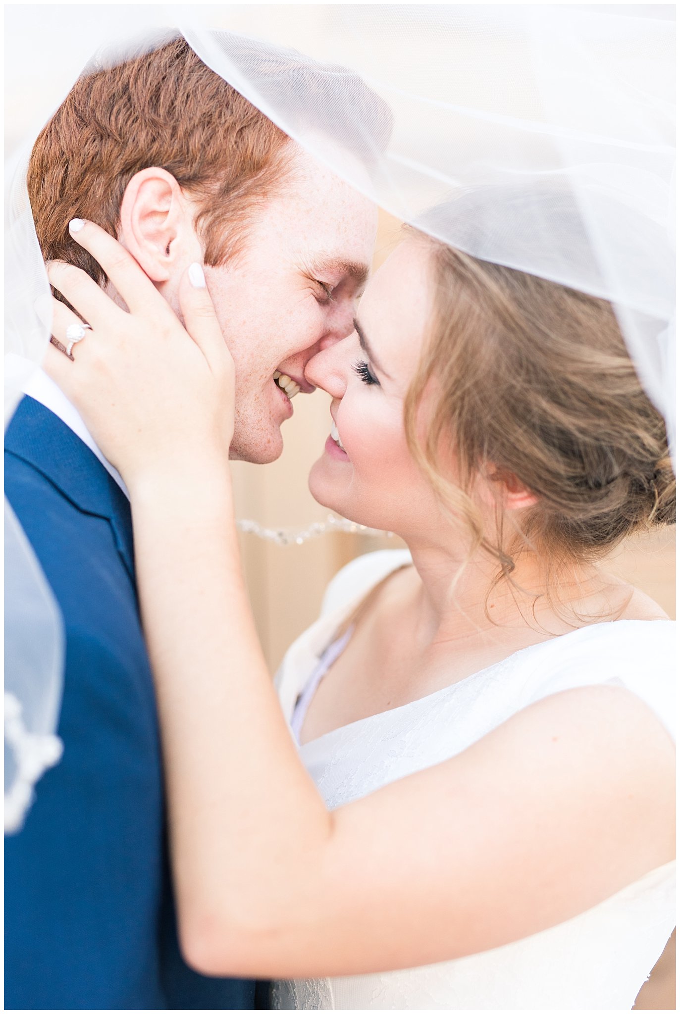 Bride and groom portrait under the veil with bride in simple elegant dress and groom in blue suit with blush tie at the Bountiful Temple | Bountiful Temple Summer Formal Session | Utah Weddings | Jessie and Dallin Photography