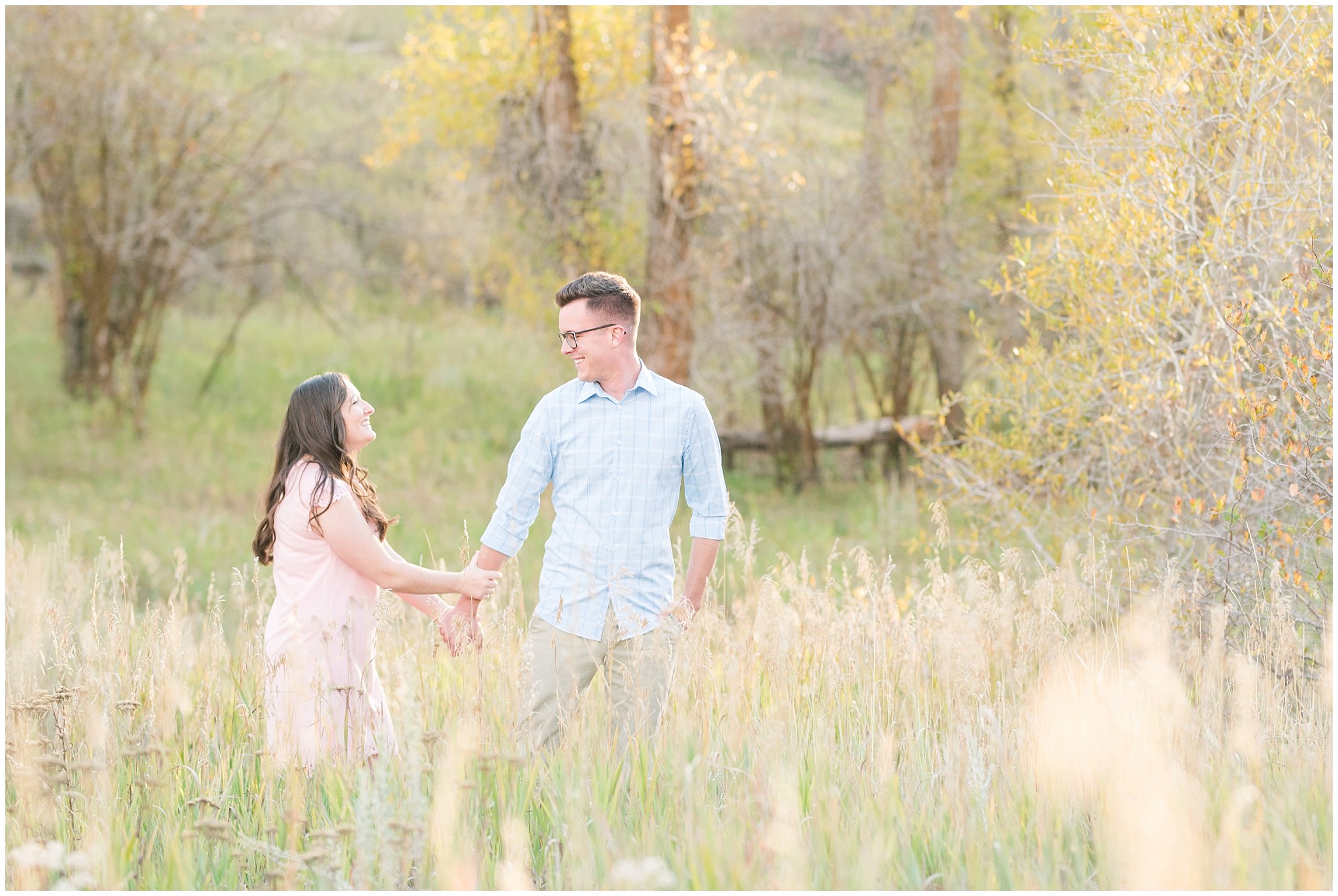 Couple in light blue shirt, tan pants and blush dress | Snowbasin woods and fall trees | A Classic Snowbasin Fall Engagement Session | Jessie and Dallin Photography
