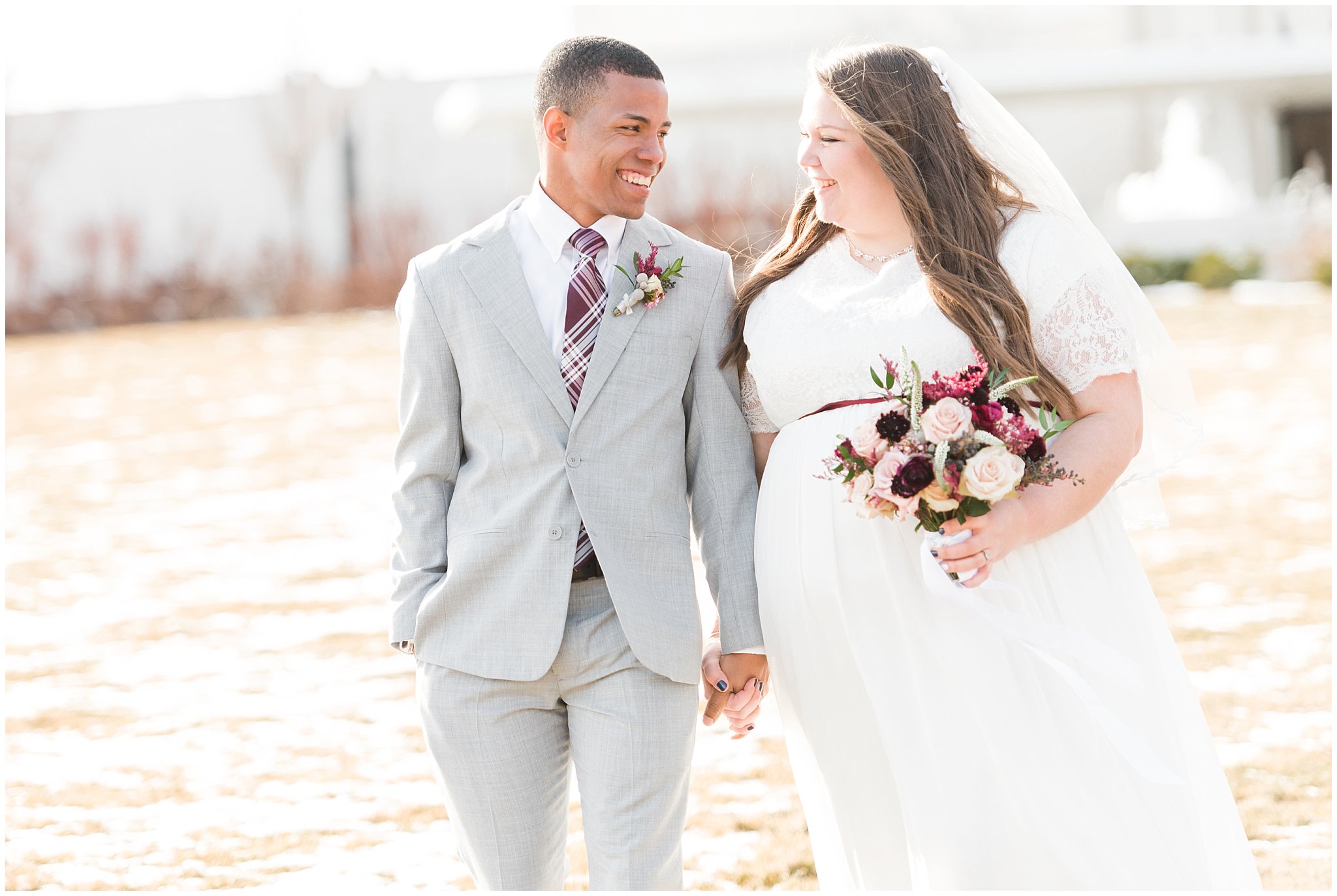 Bride and groom portraits with bride in a dress from Latterdaybride and groom in light grey suit | burgundy and quicksand rose bouquet by Dancing Daisies Floral | Jordan River Temple Winter Wedding | Jessie and Dallin Photography