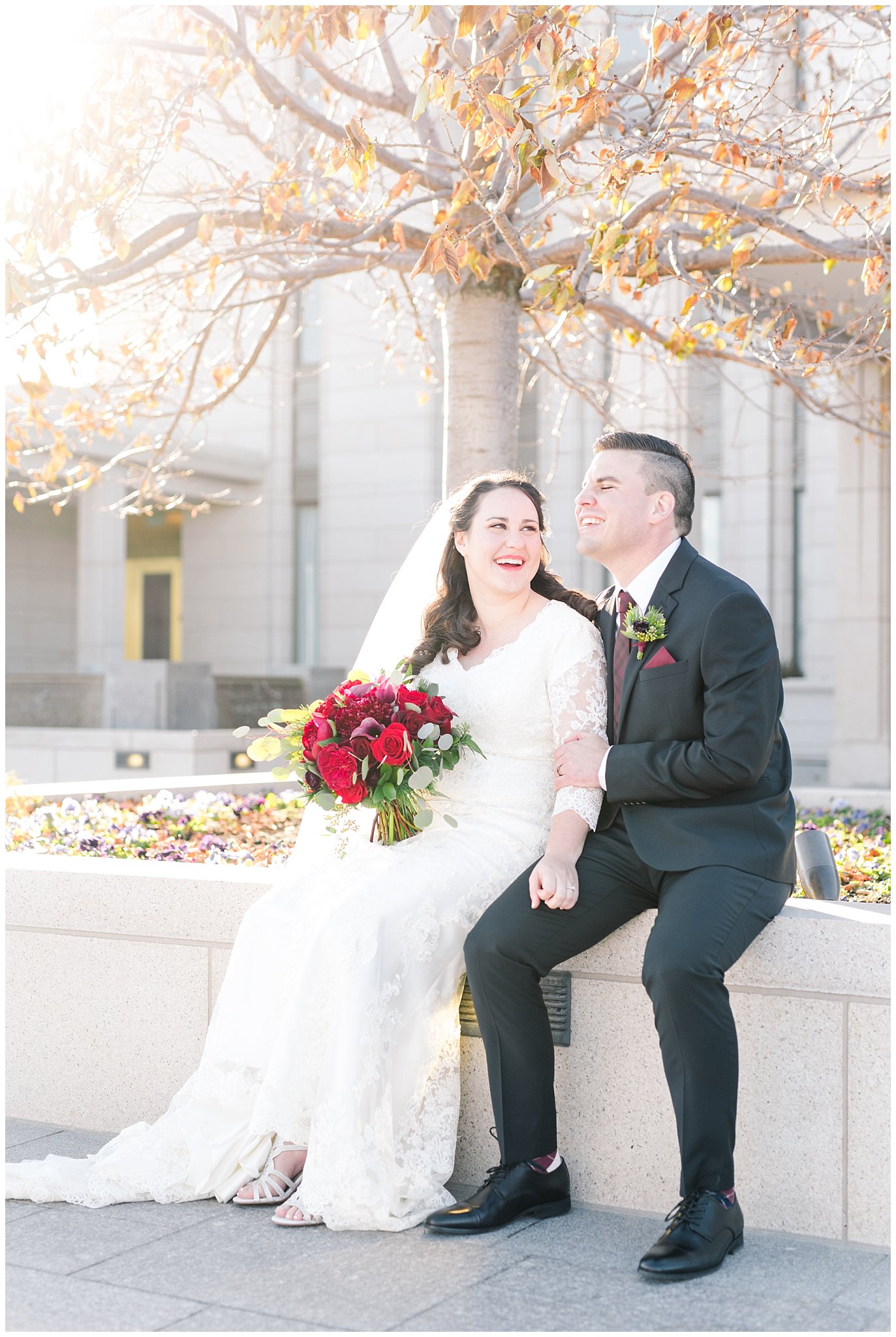 Bride and groom portraits with a veil, flowy lace dress and black suit with red and white bouquet at the Oquirrh Mountain Temple | Oquirrh Mountain Temple and Gardner Village Wedding | The Gathering Place | Jessie and Dallin Photography