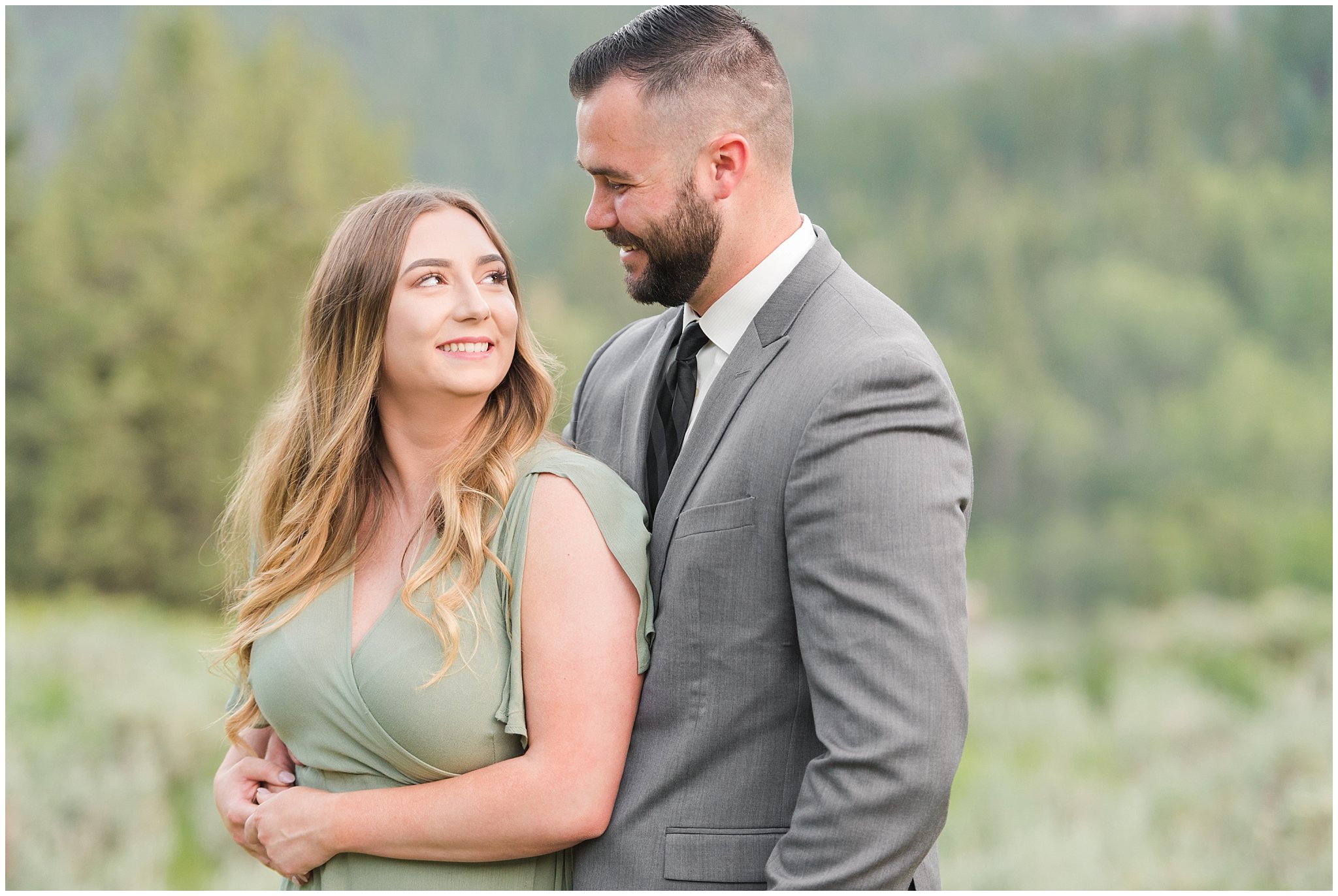 Couple in sage green dress and grey suit in the mountains | Tibble Fork Summer Engagement Session | Jessie and Dallin Photography