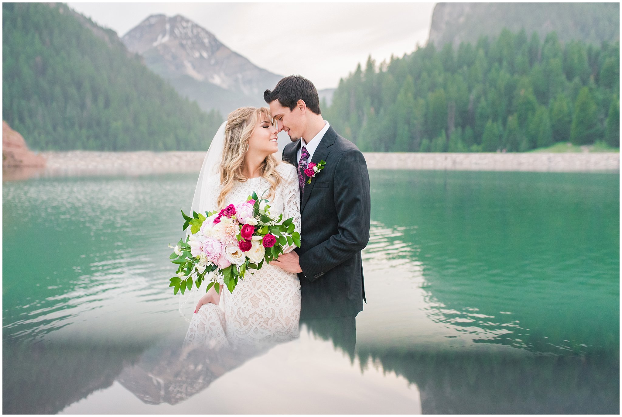 Candid photos of bride in lace dress and groom in black suit with deep pink and white floral bouquet | Utah Mountains and reservoir water Wedding Formal Session | Tibble Fork Summer Formal Session | Jessie and Dallin Photography