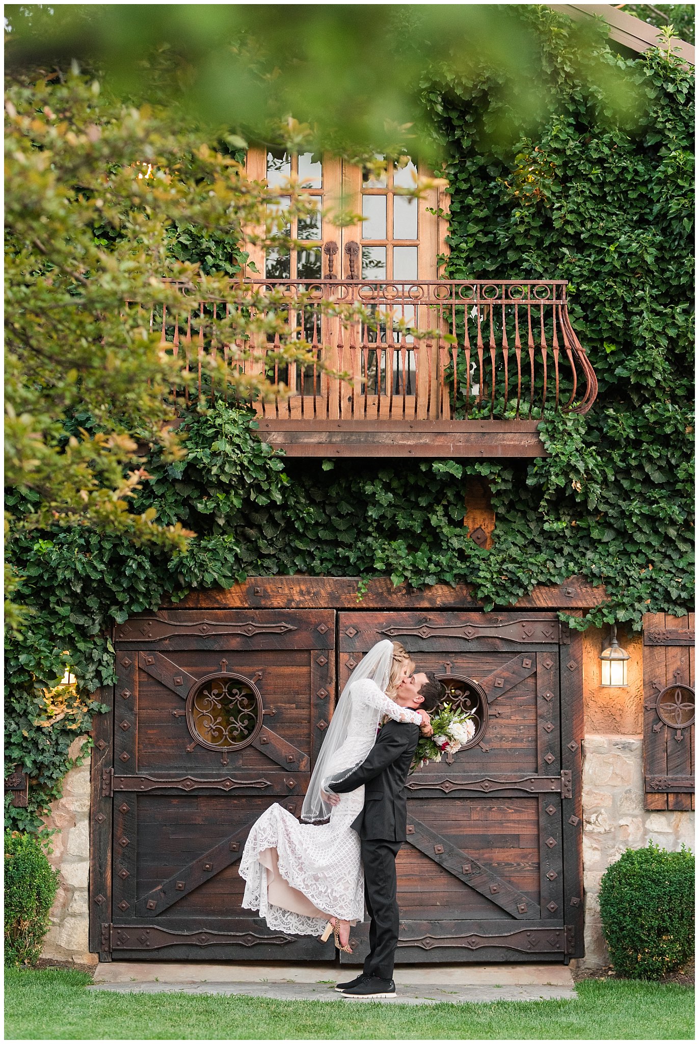 Bride and groom portrait in front of big barn doors | white and deep pink florals with black suit and lace dress | Wadley Farms Summer Wedding | Jessie and Dallin Photography