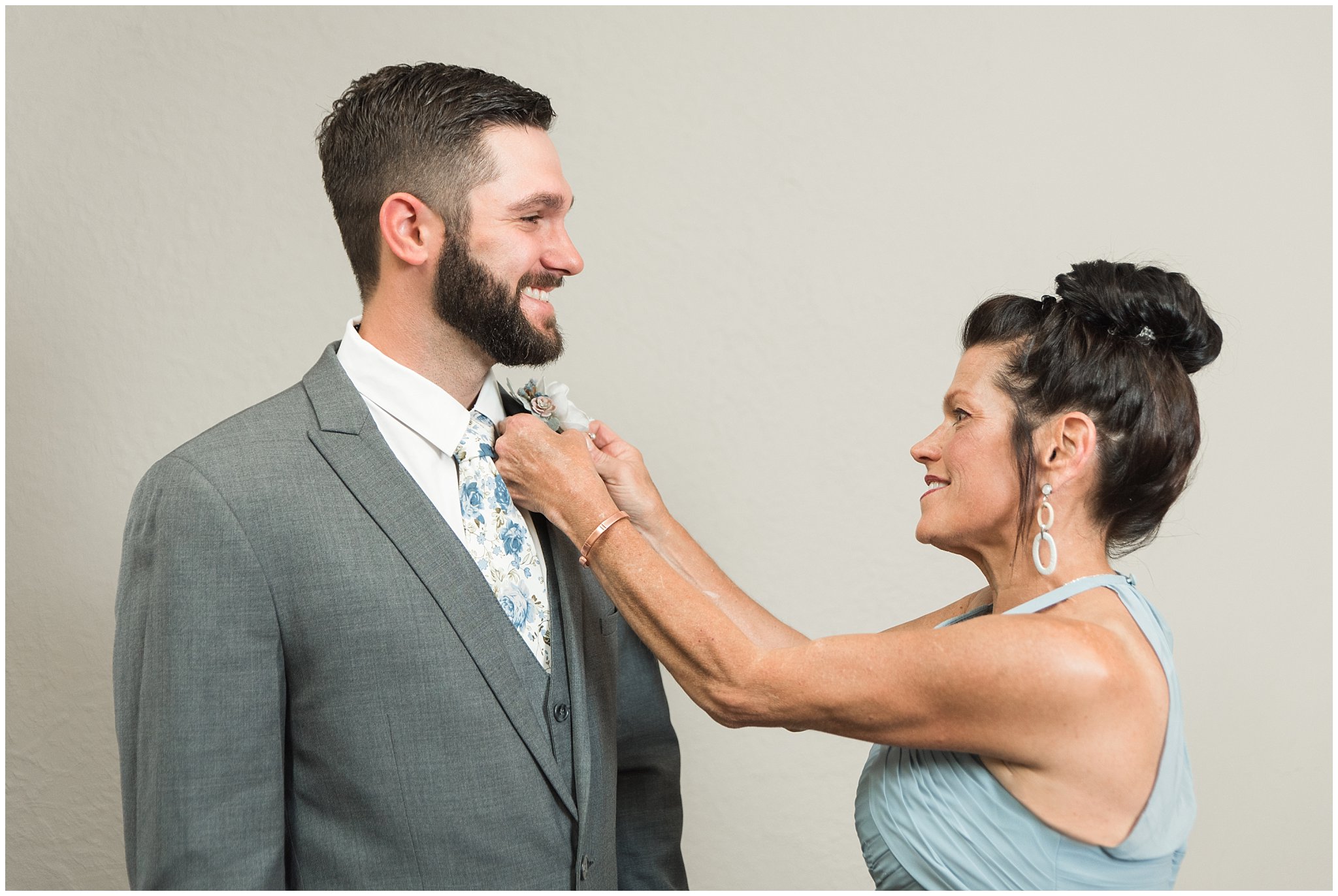 Groom getting ready with a gray suit and blue and white floral tie | Dusty Blue and Rose Summer Wedding at Oak Hills Utah | Jessie and Dallin Photography