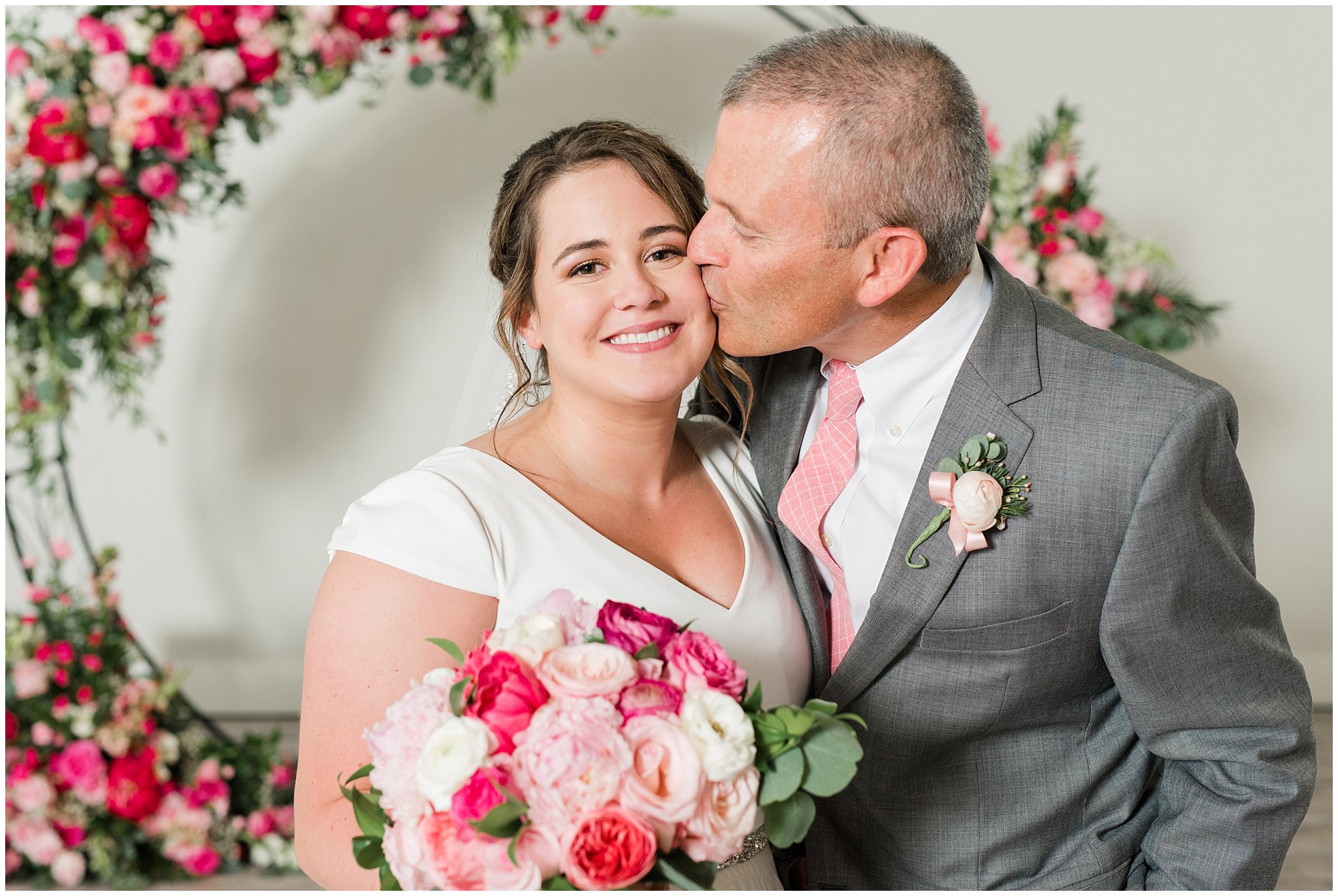 Family portraits in front of floral arch in shades of pink | Talia Event Center Summer Wedding | Jessie and Dallin Photography