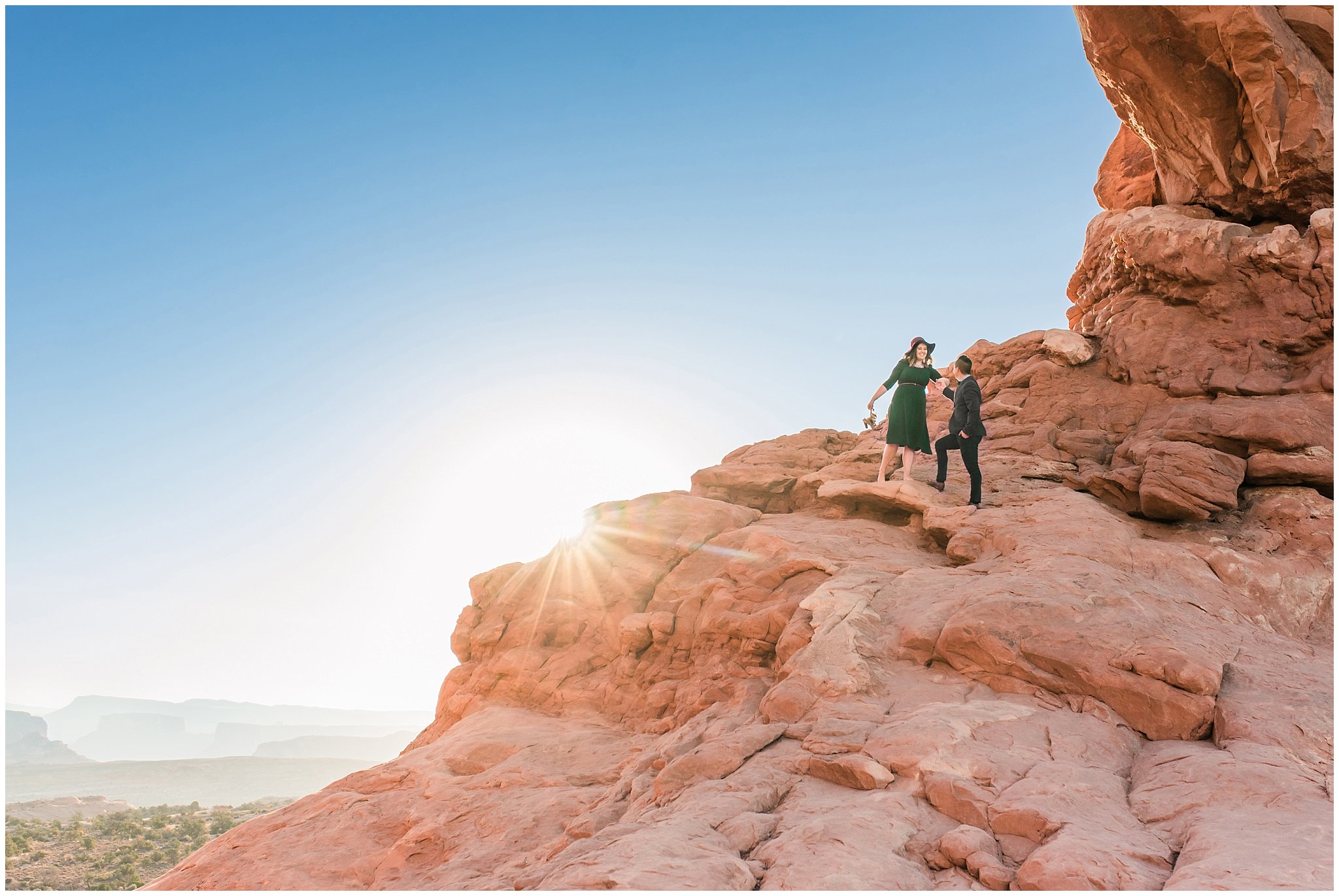 Couple dressed in green dress and grey and blue suit with bowtie for adventure engagement session at Arches National Park and Dead Horse Point Engagement | Jessie and Dallin Photography