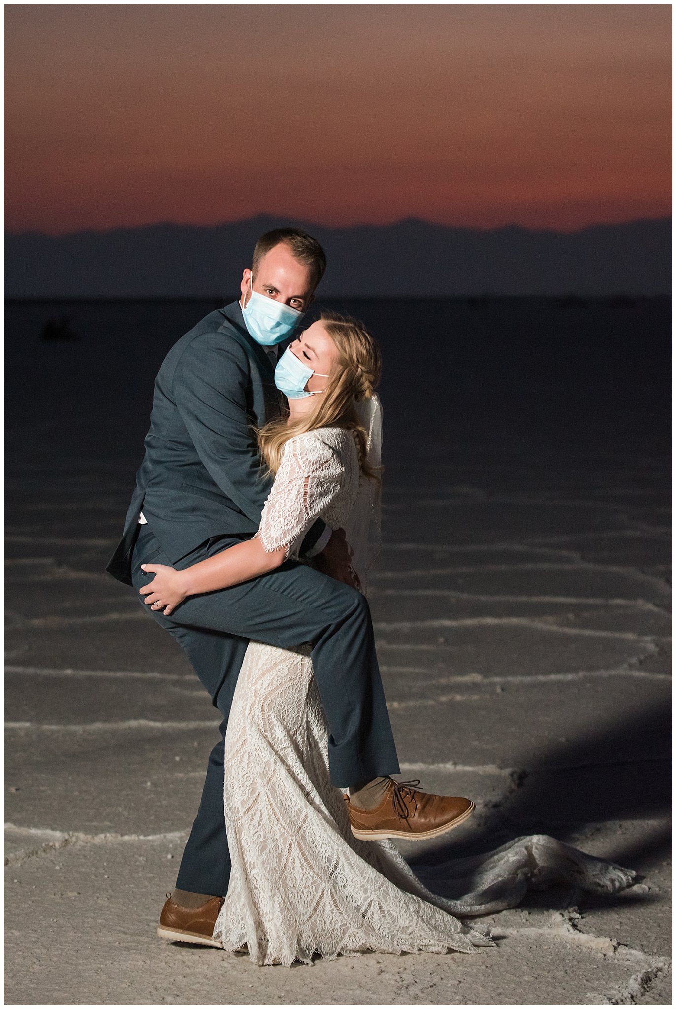 Bride and Groom at sunset in lace detail dress and blue suit for Adventure Session | Bonneville Salt Flats Sunset Wedding Formal Session | Jessie and Dallin Photography