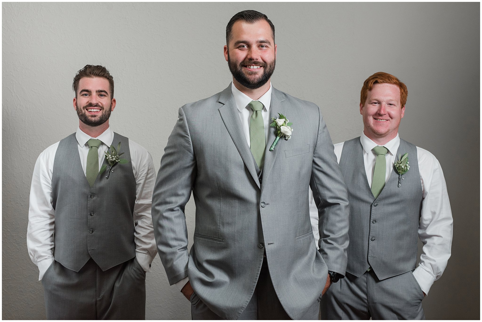 Groom with groomsmen getting ready in gray suits and sage green ties and giving groomsmen axes | Sage Green and Gray Summer Wedding at Oak Hills | Jessie and Dallin Photography