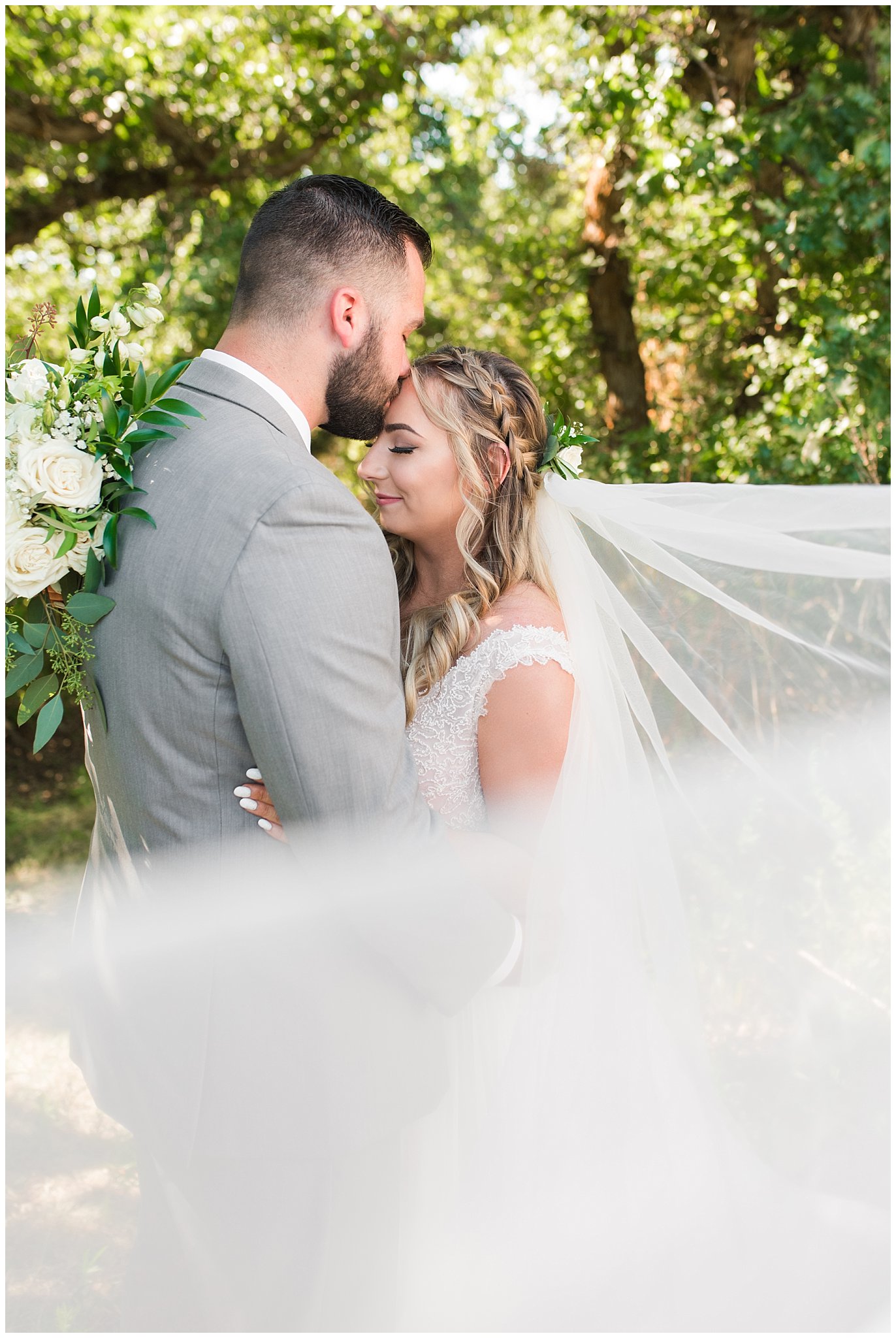 Bride and groom first look in woods wearing gray suit and sage green tie and champagne dress with veil | Sage Green and Gray Summer Wedding at Oak Hills | Jessie and Dallin Photography