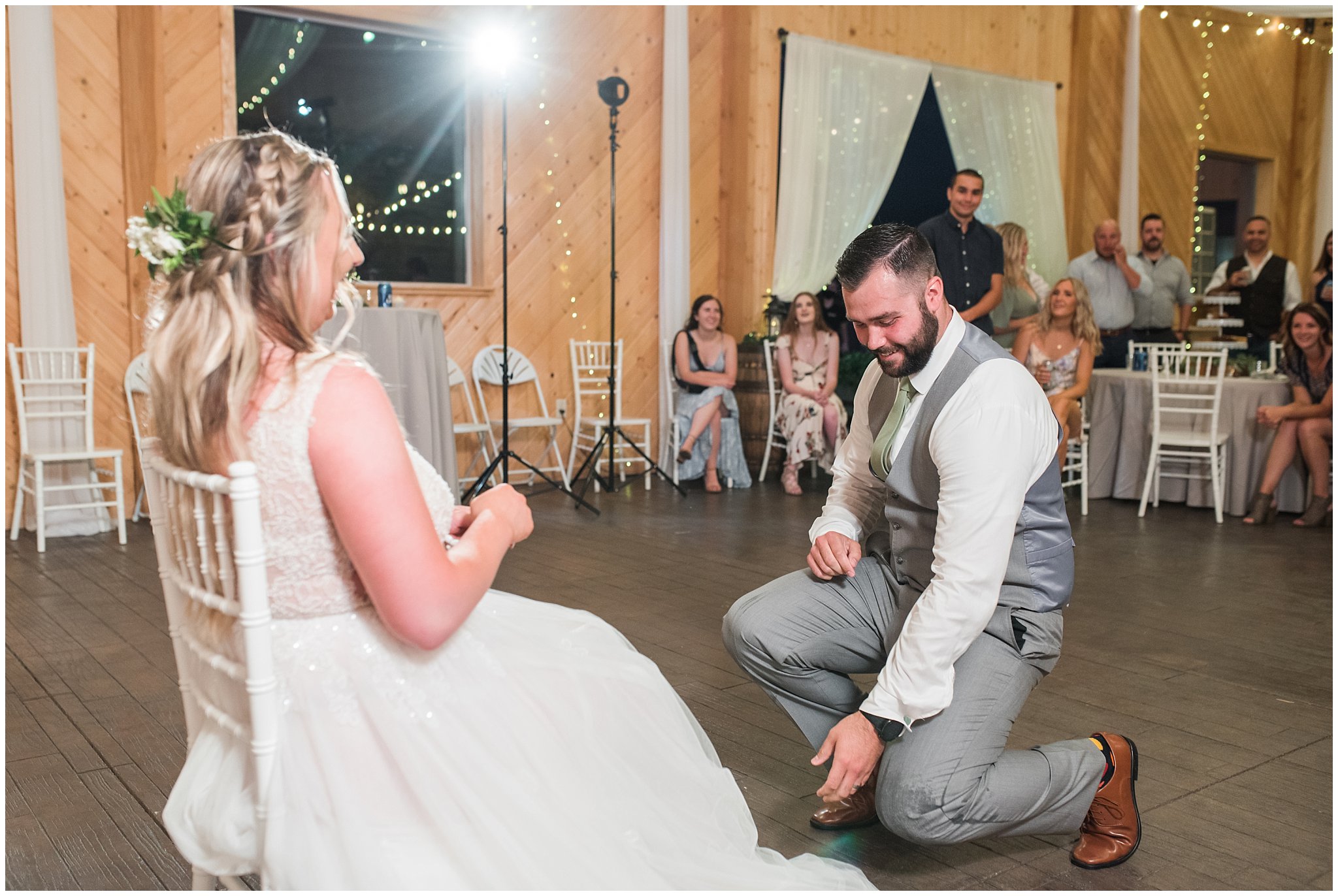 Garter toss in a barn during wedding reception | Sage Green and Gray Summer Wedding at Oak Hills | Jessie and Dallin Photography