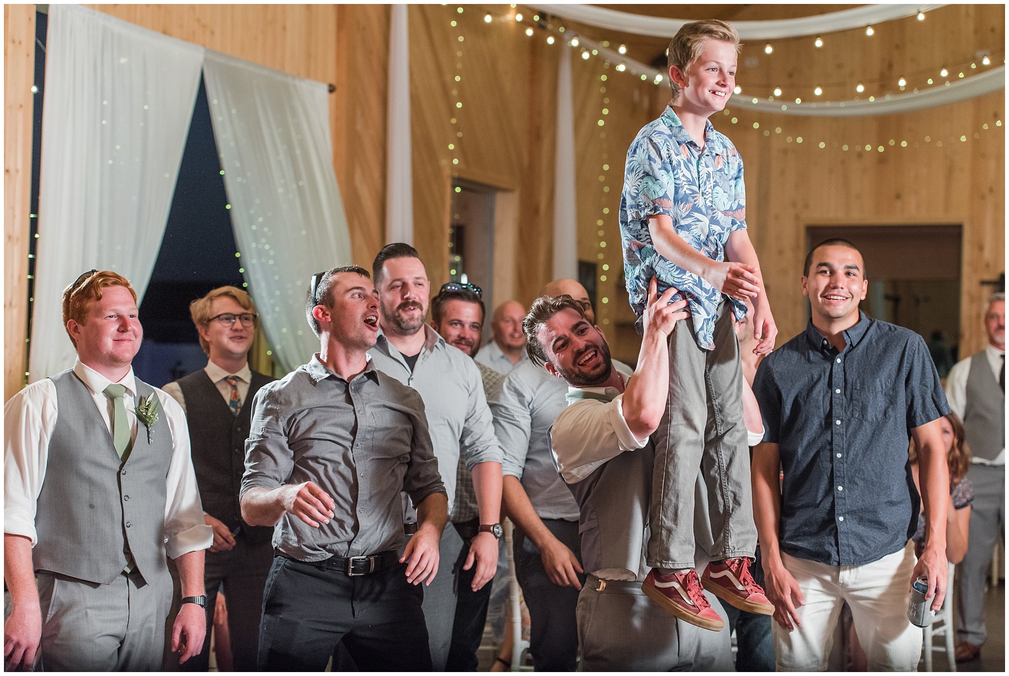 Garter toss in a barn during wedding reception | Sage Green and Gray Summer Wedding at Oak Hills | Jessie and Dallin Photography