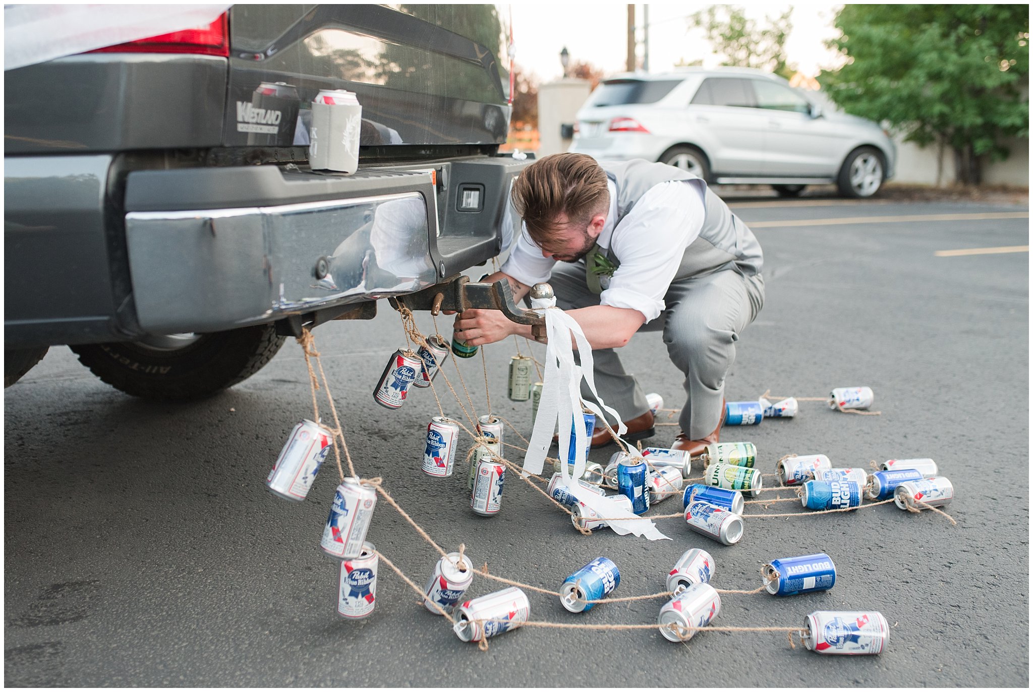 Wedding party trashing the car with cans and car chalk | Sage Green and Gray Summer Wedding at Oak Hills | Jessie and Dallin Photography