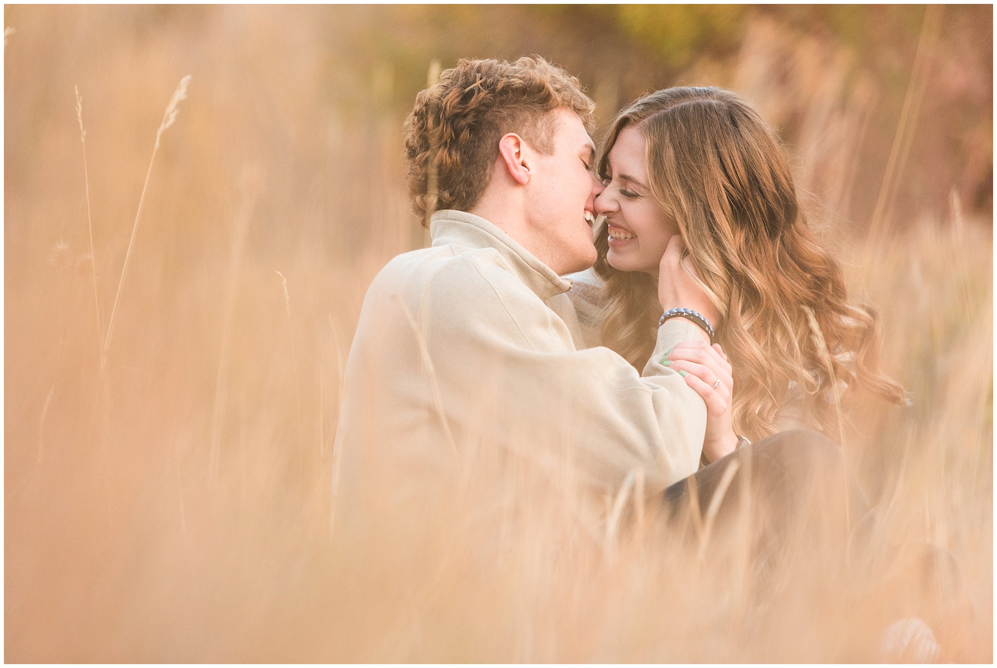 Candid photos of couple in casual cream colored fall sweaters | Utah Fall Engagement Session in a Golden Field | Jessie and Dallin Photography