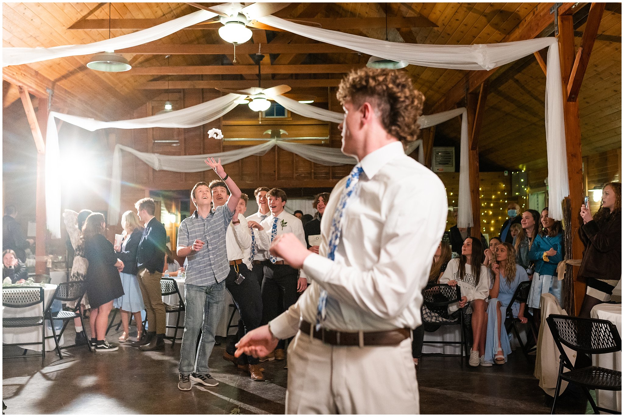 Garter toss during barn wedding | Oquirrh Mountain Temple and Draper Day Barn Winter Wedding | Jessie and Dallin Photography
